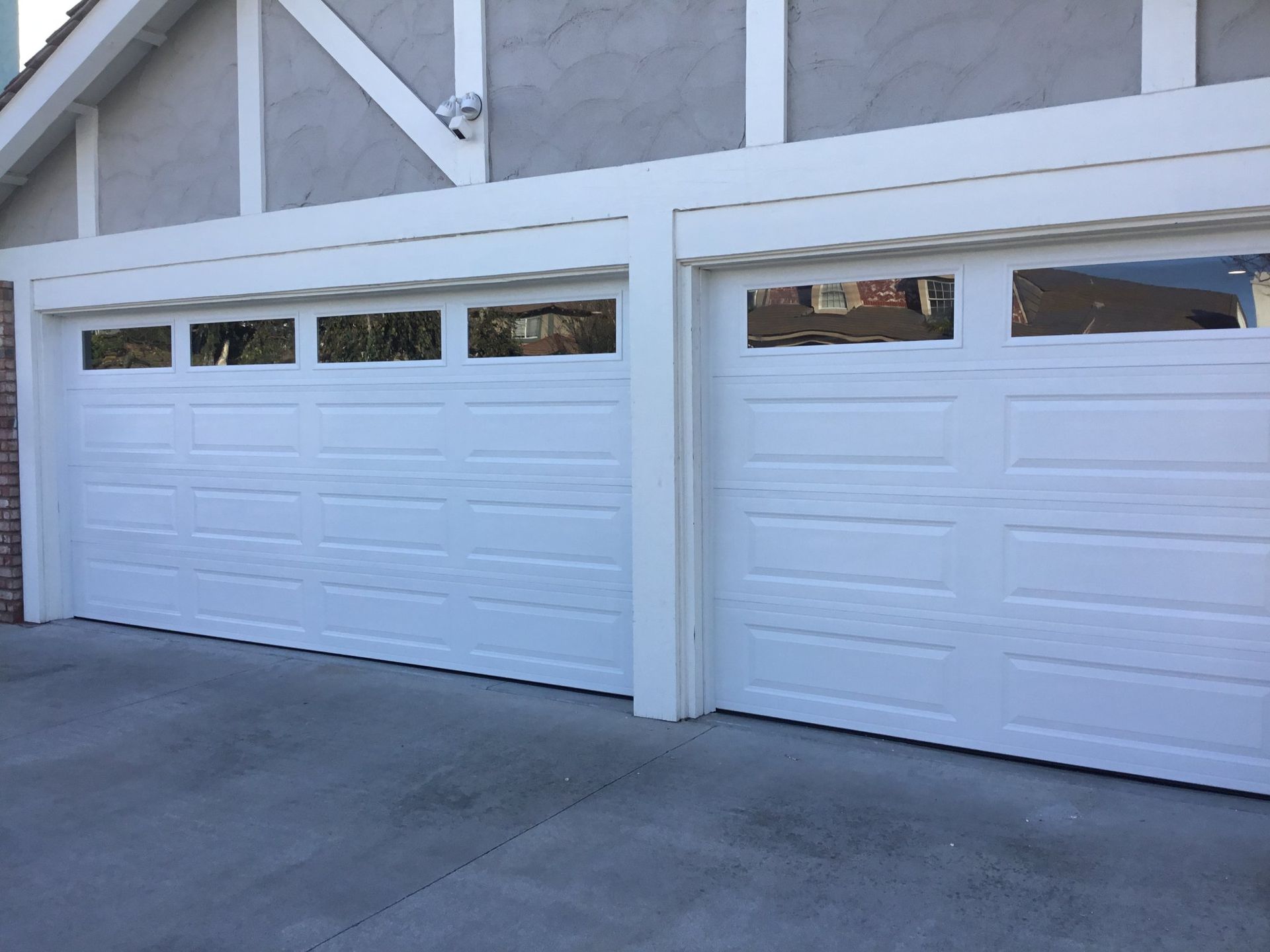 A couple of white garage doors on a house