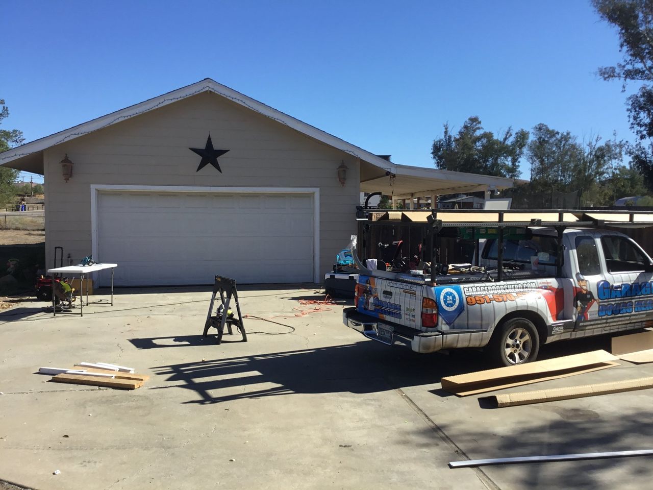 A truck is parked in front of a garage with a star on the roof.
