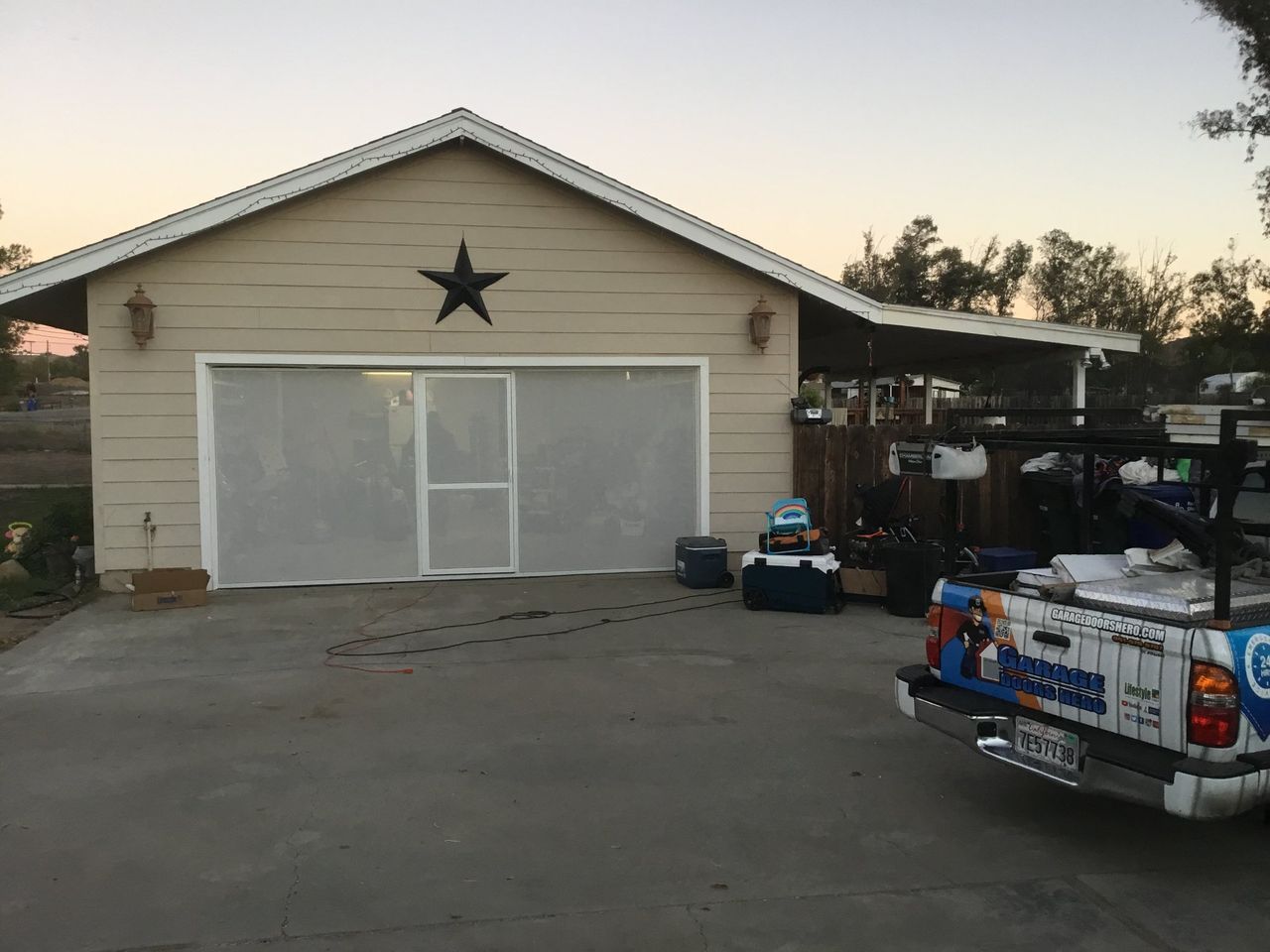 A truck is parked in front of a garage with a star on the roof.