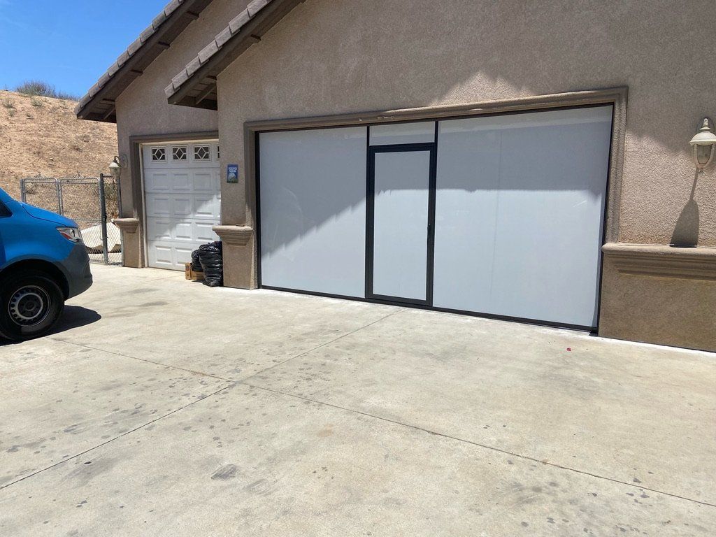 A blue van is parked in front of a garage door
