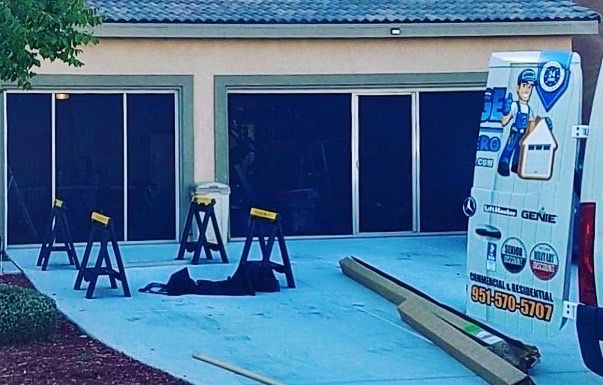 A van is parked in front of a house with sliding glass doors.