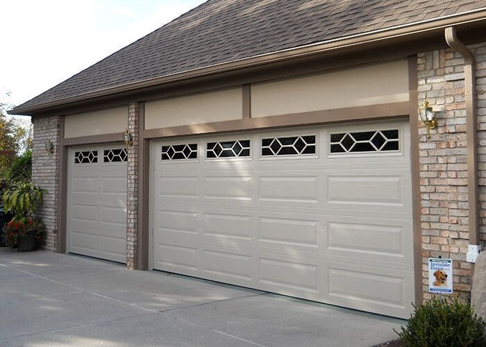 A brick building with three white garage doors