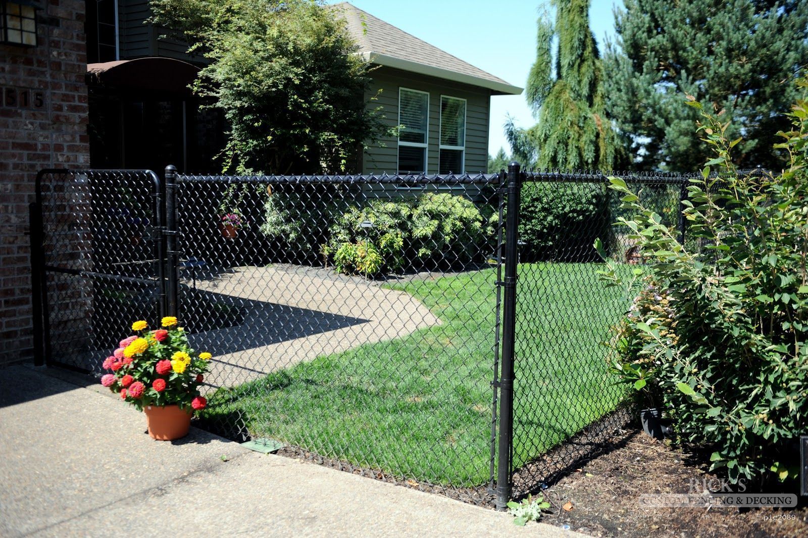 A black chain link fence is in front of a house