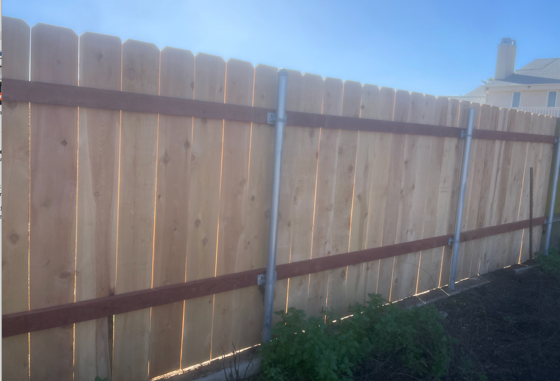A wooden fence with a blue sky in the background