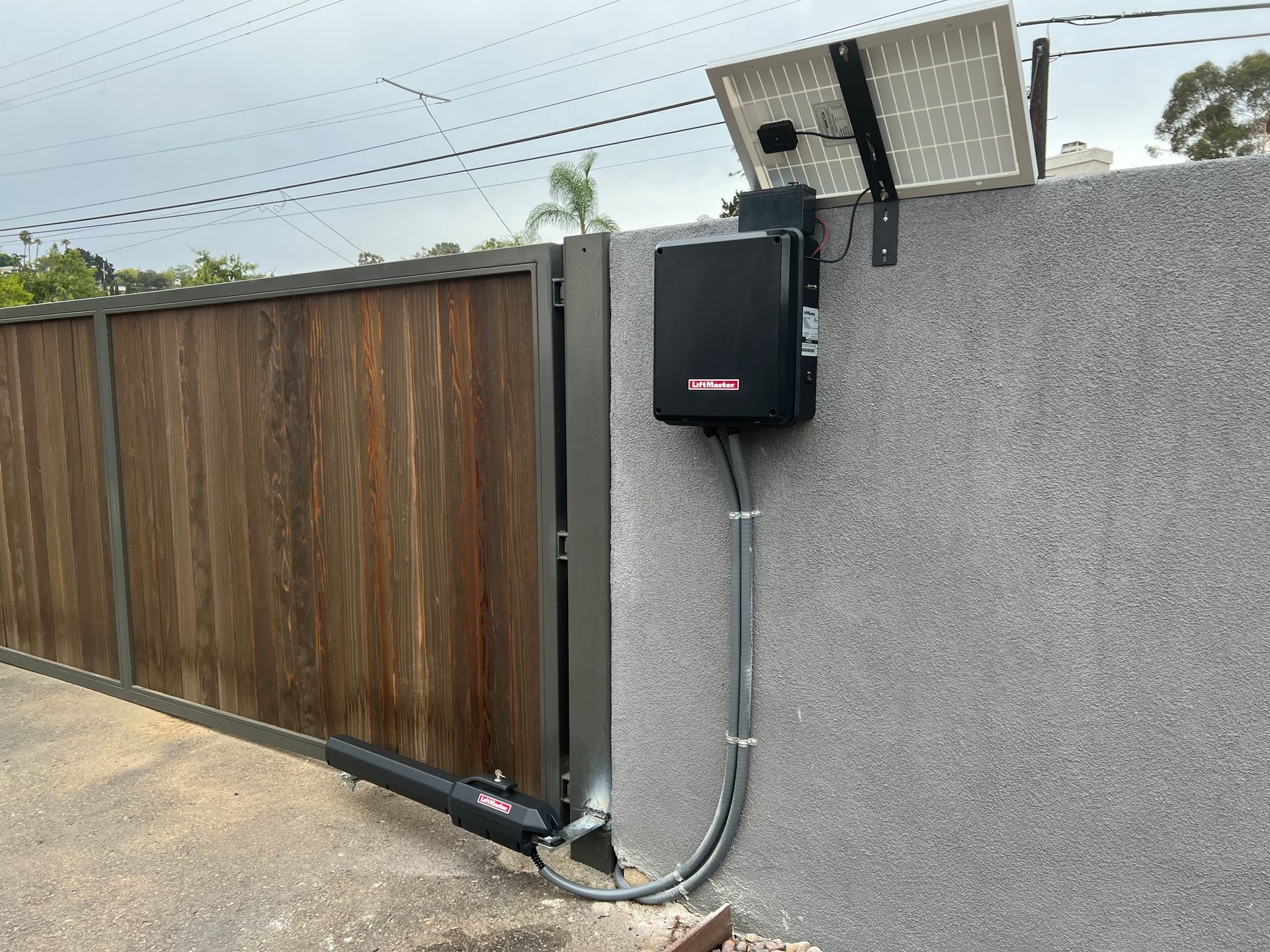 A wooden gate with a black box attached to it.