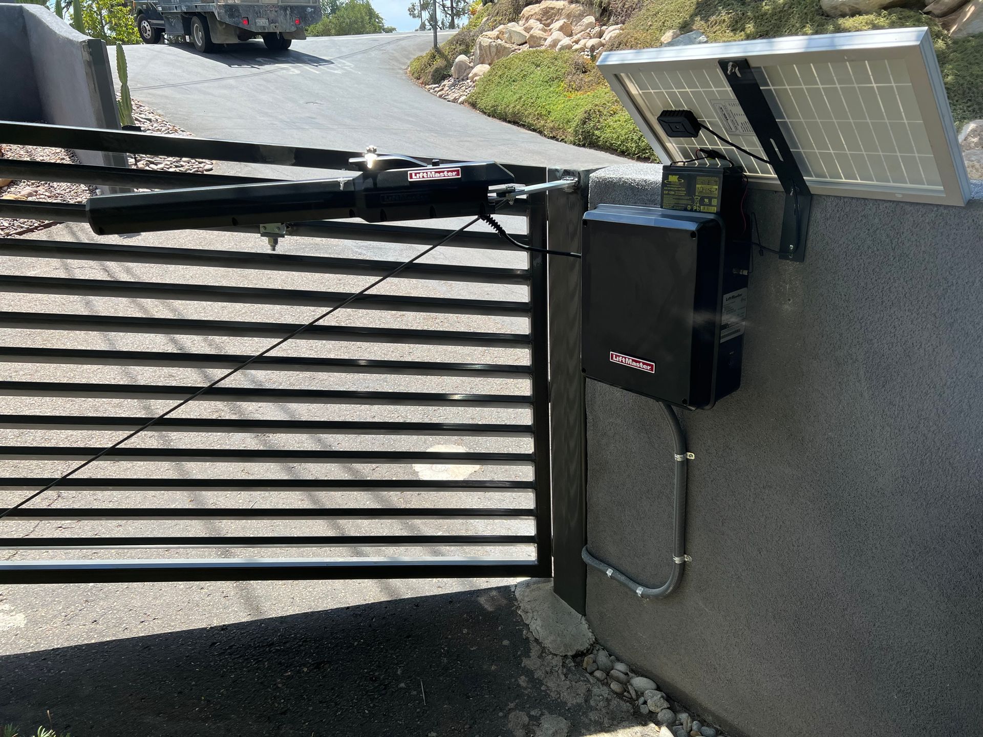 A black gate with a solar panel attached to it