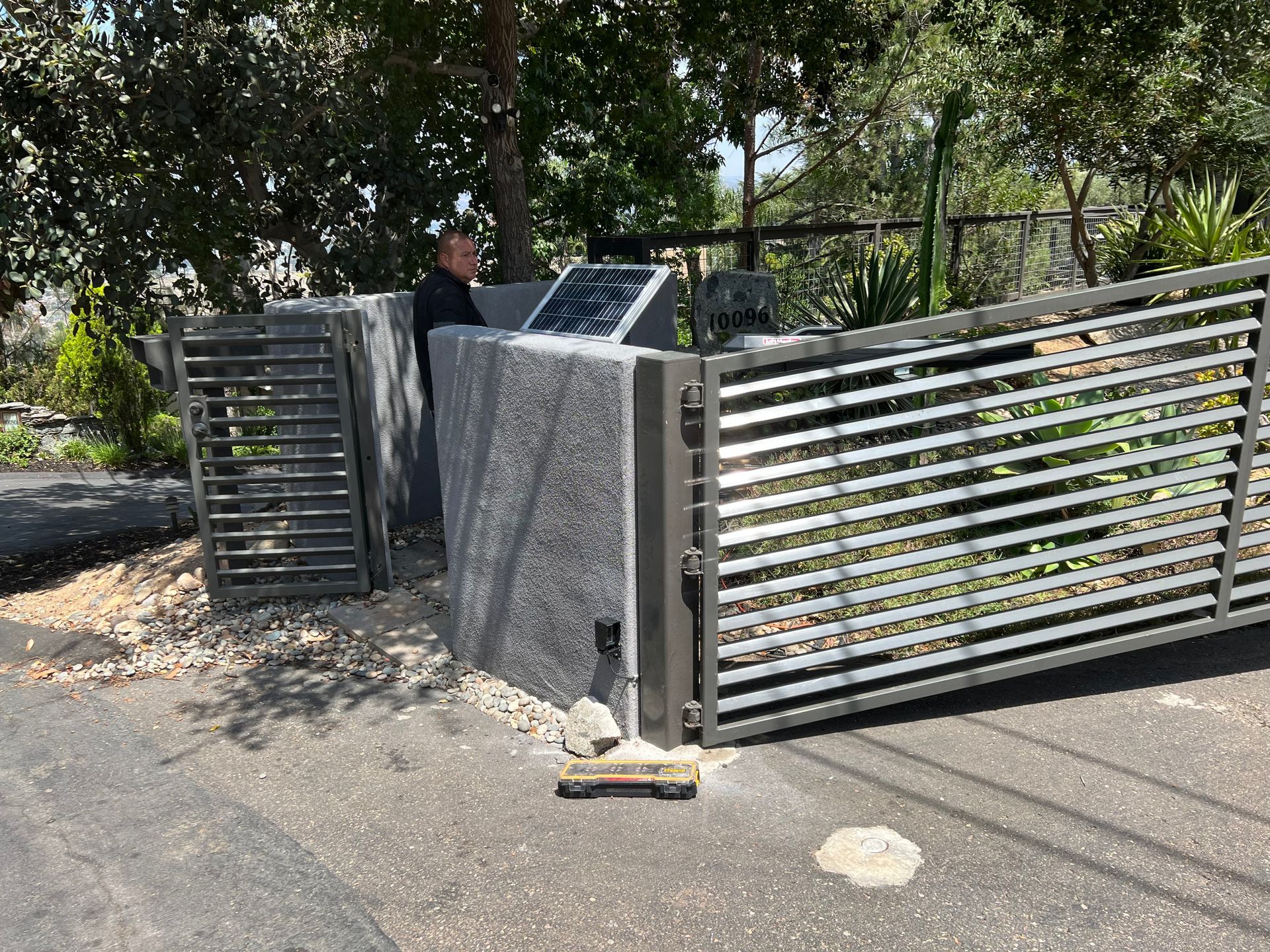 A man is standing in front of a sliding gate.