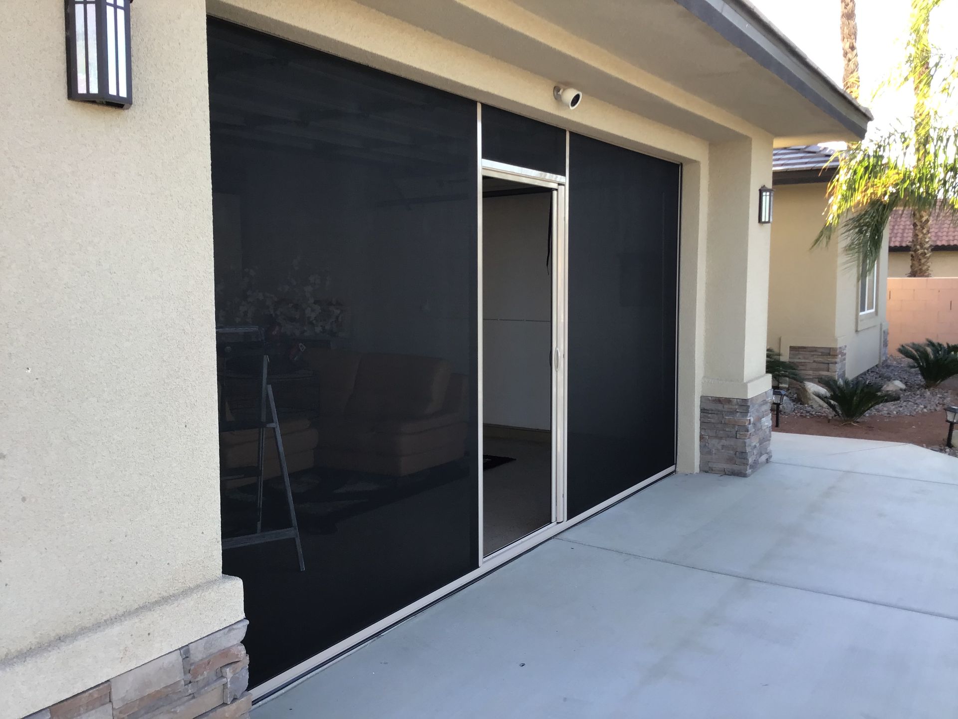 A house with a screened in garage door and a screened in porch.
