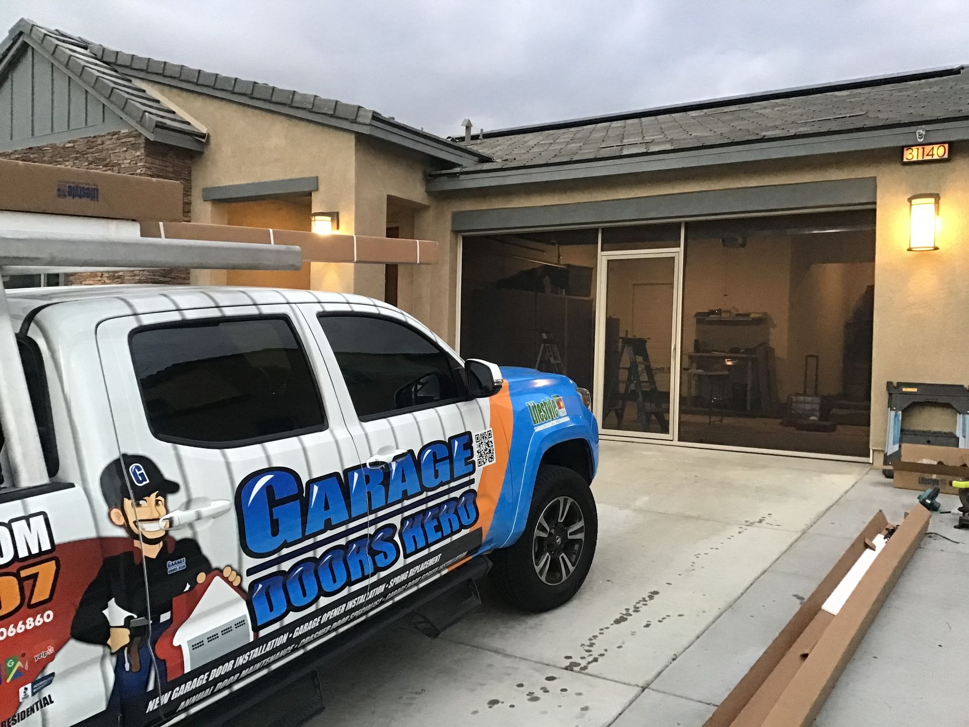 A garage door repair truck is parked in front of a house.