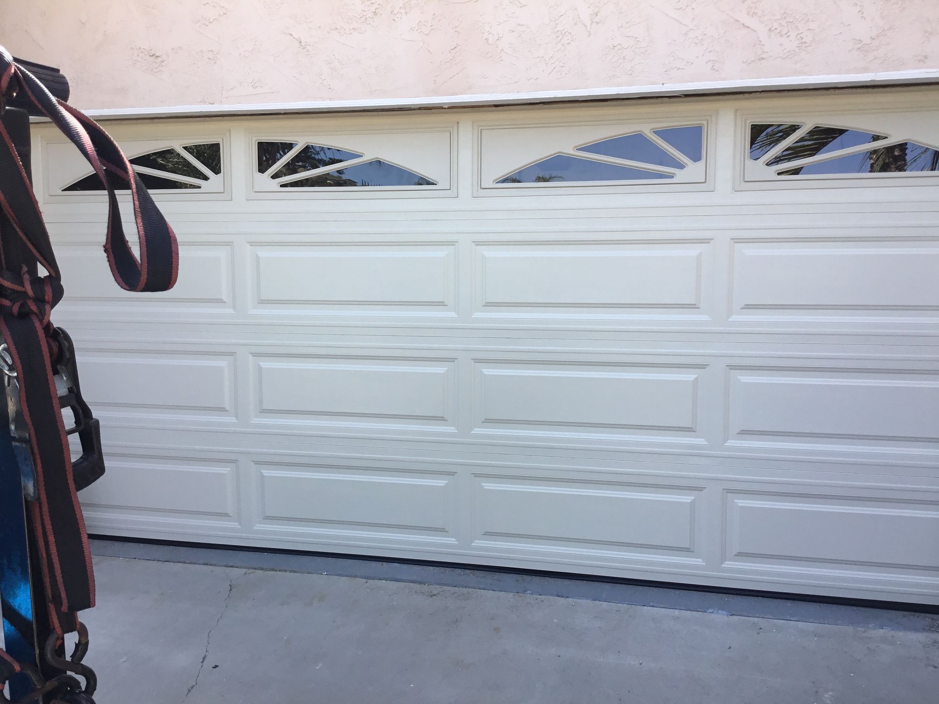 A person is standing in front of a white garage door