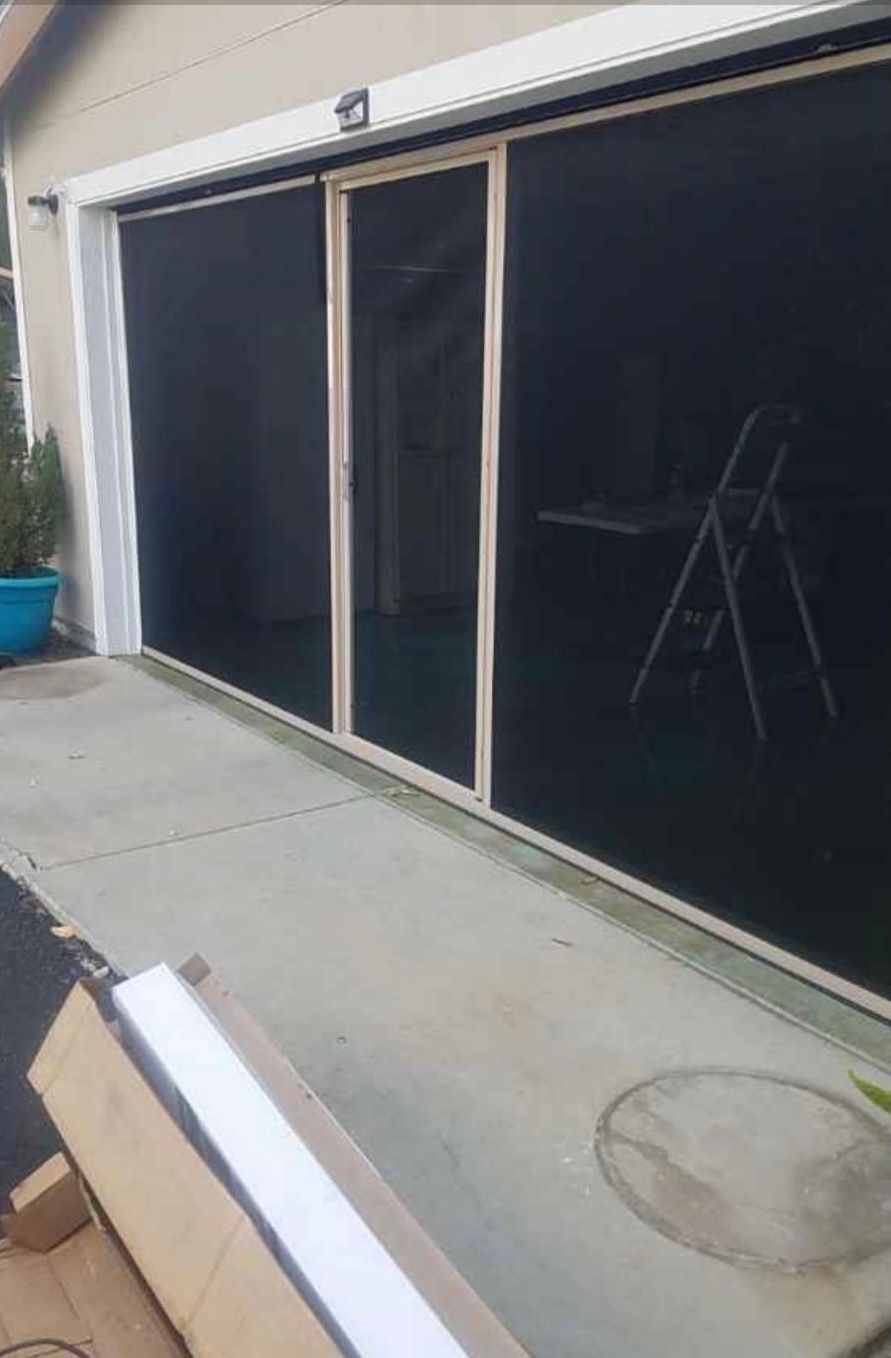 A screen door is being installed on a garage door.