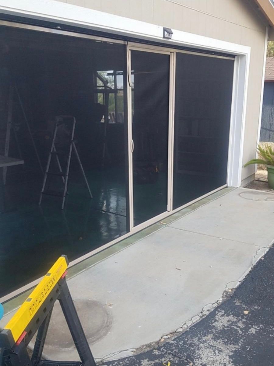 A screen door is being installed on a garage door.