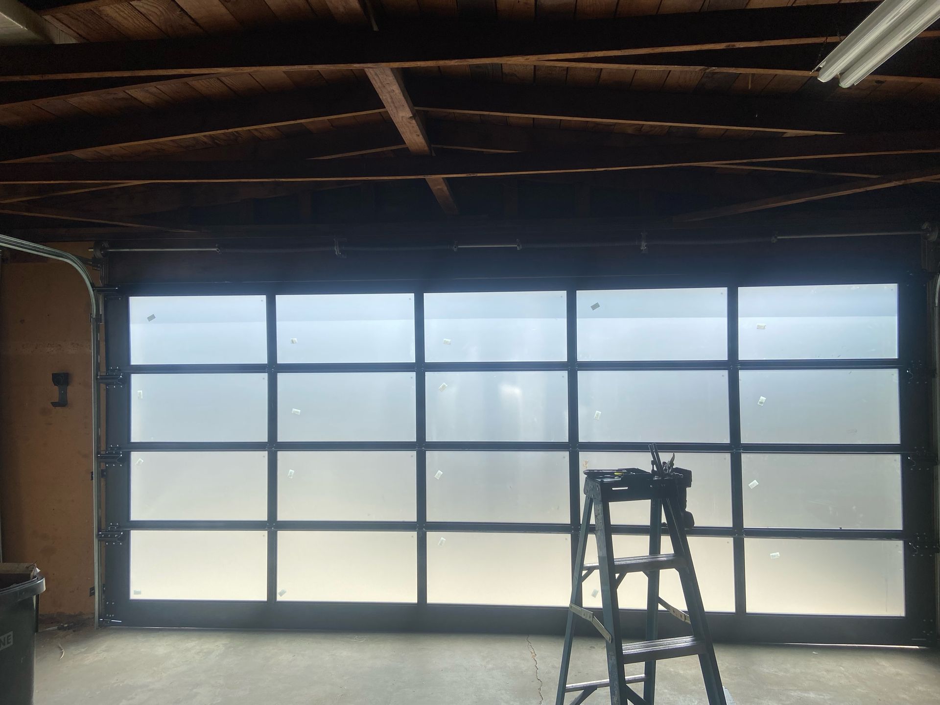 A garage door with a ladder in front of it
