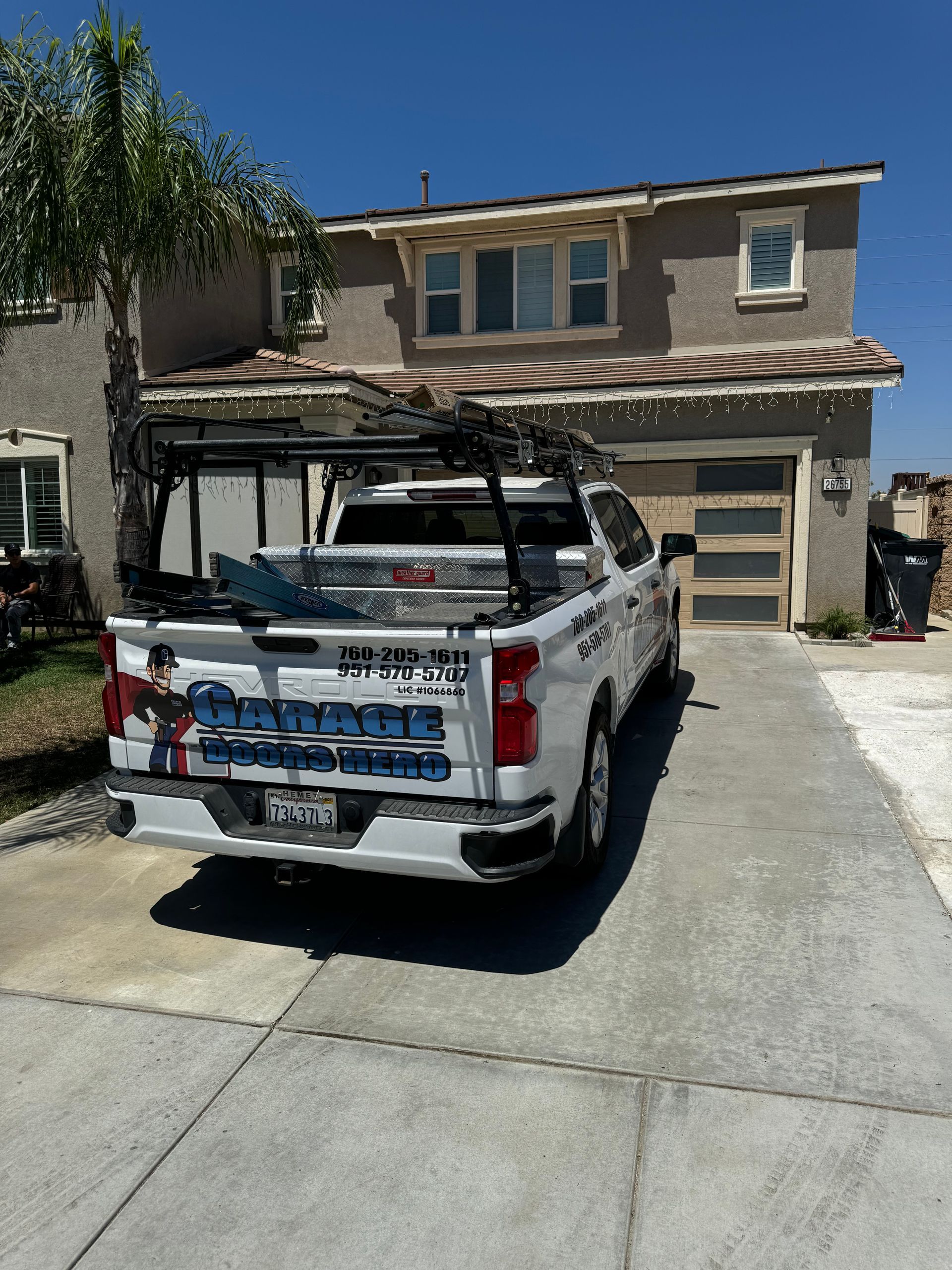 A white truck is parked in front of a house.