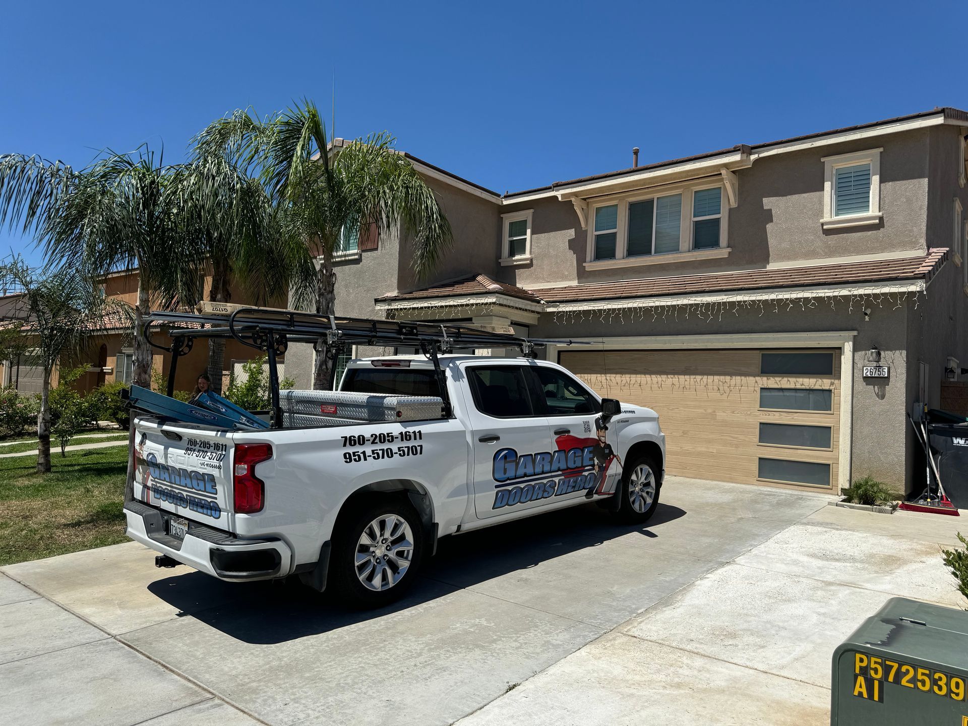 A white truck is parked in front of a large house.