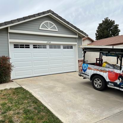 A golf cart is parked in front of a garage door.