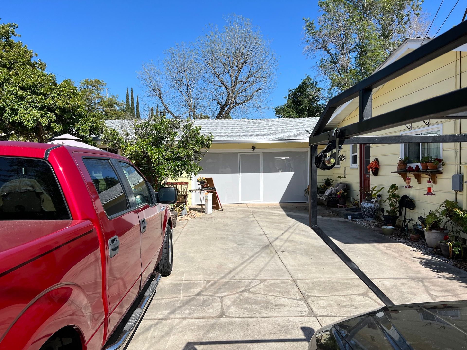 A red truck is parked in a driveway in front of a house.