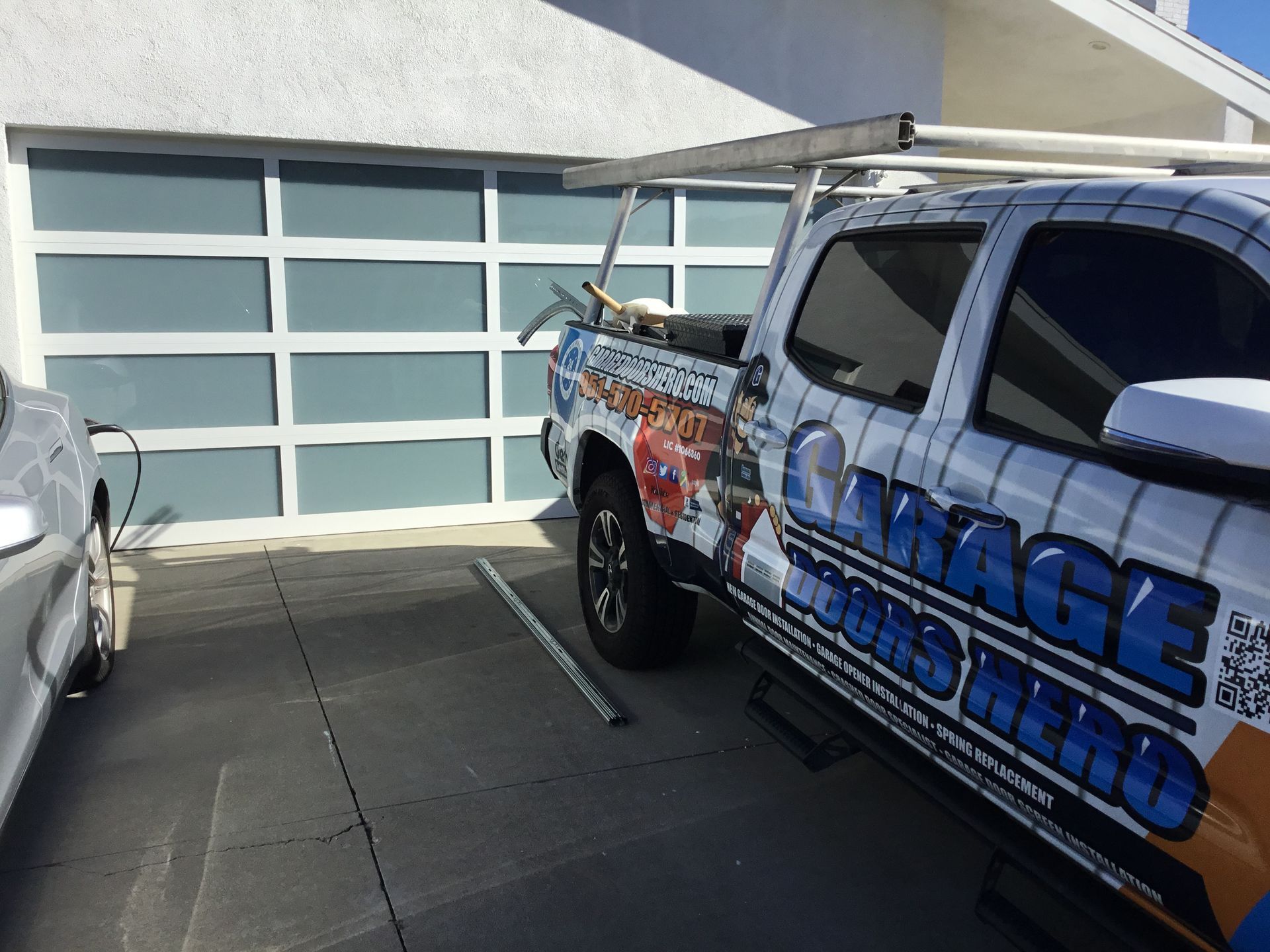 A garage doors truck is parked in front of a garage door