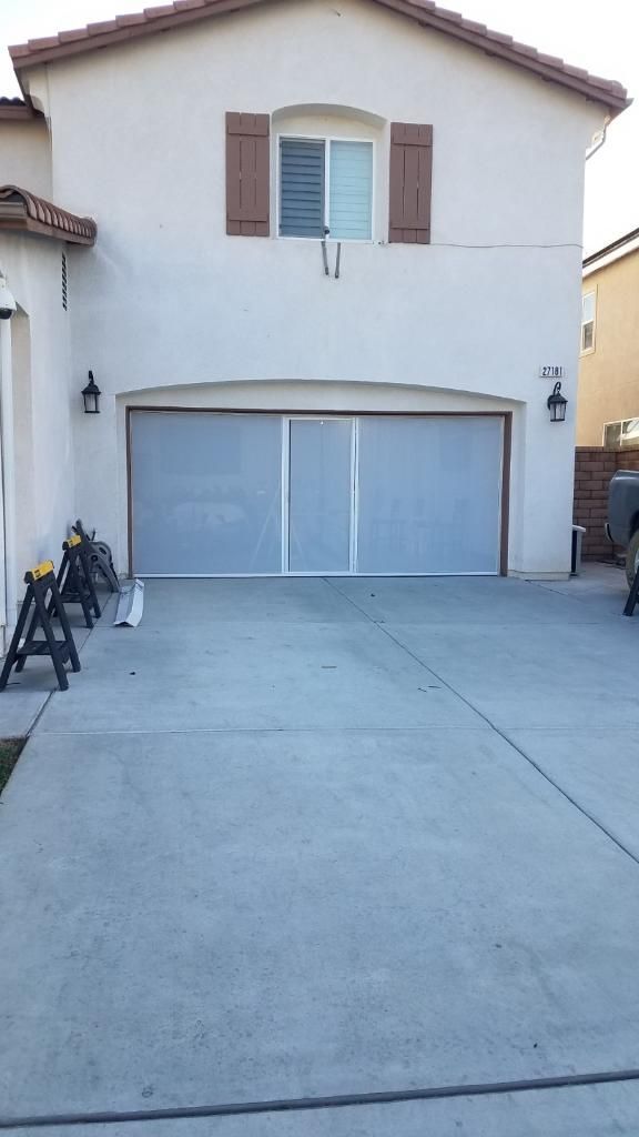 A large white house with a garage door and a driveway.