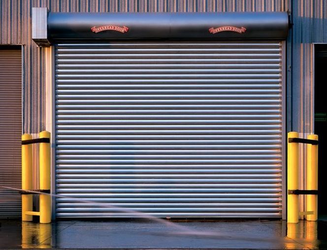 A garage door with a yellow pole in front of it.