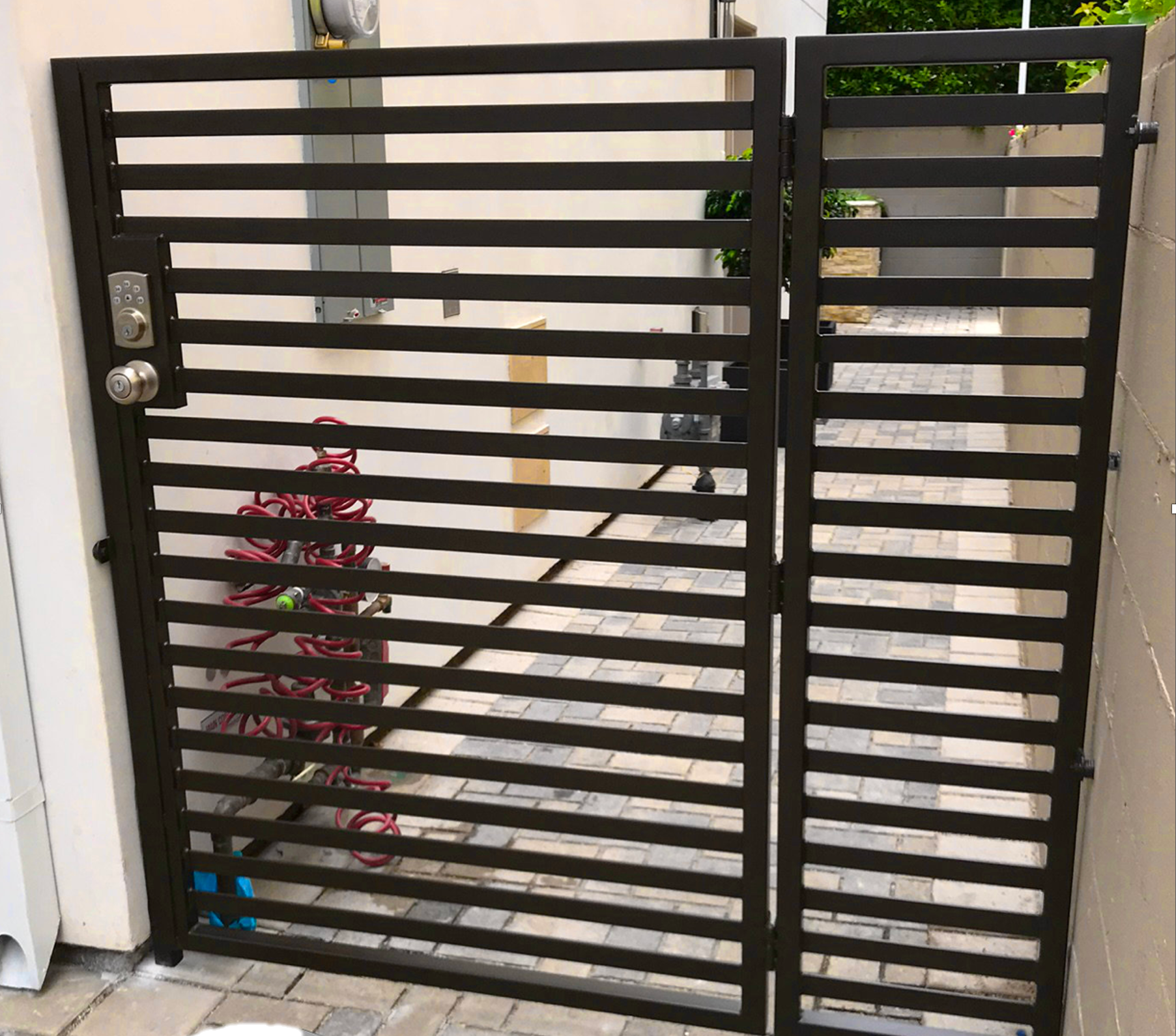 A black metal gate is sitting in front of a house.