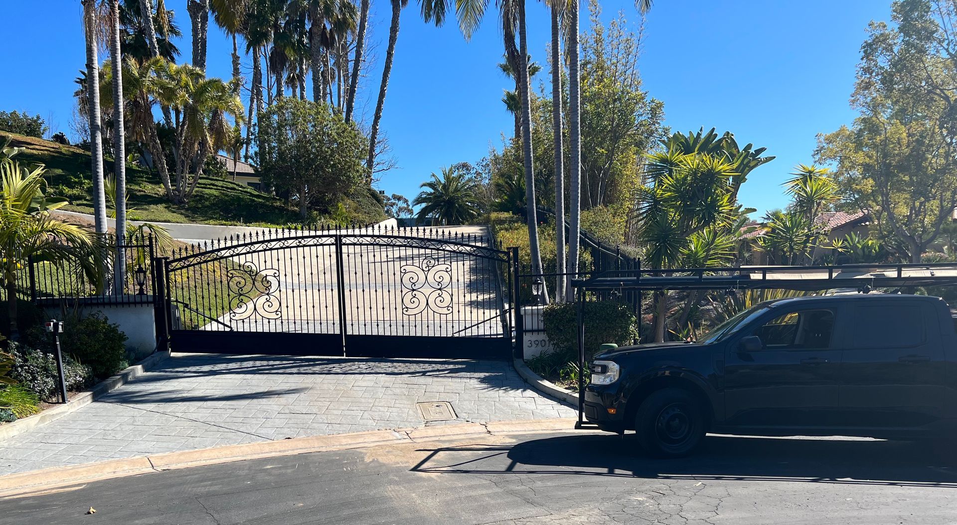 A black car is parked in front of a gate
