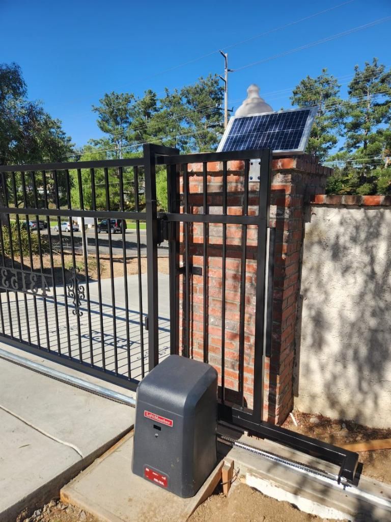 A sliding gate with a solar panel on top of it.