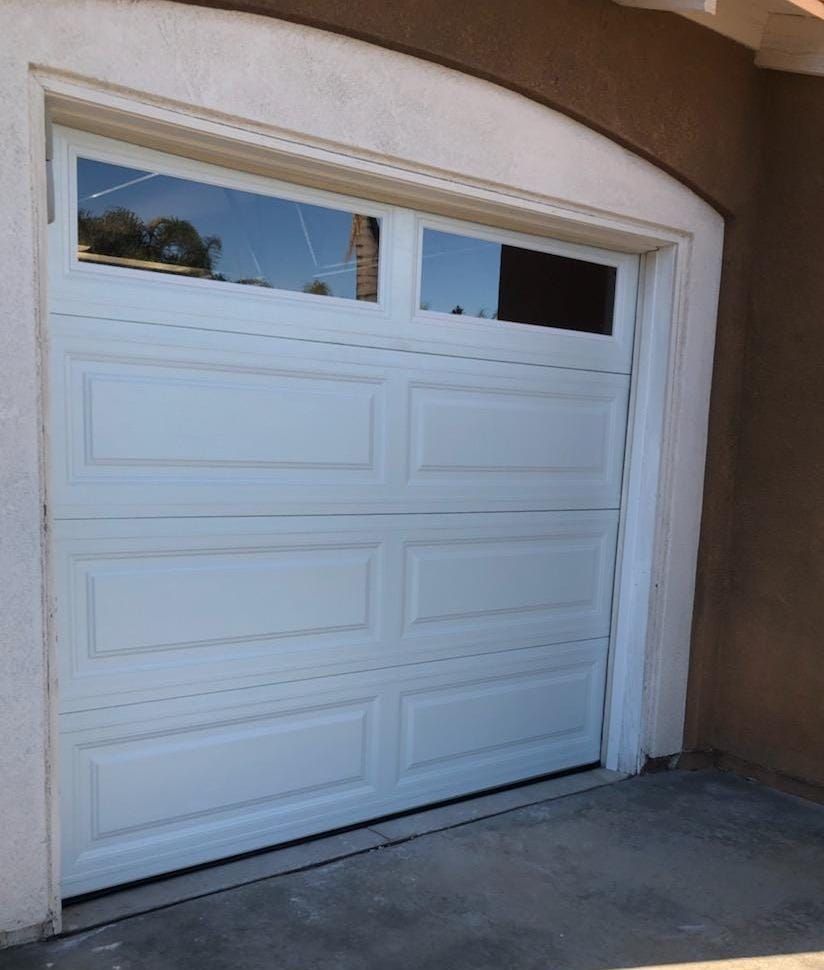A white garage door with a window on the side of it
