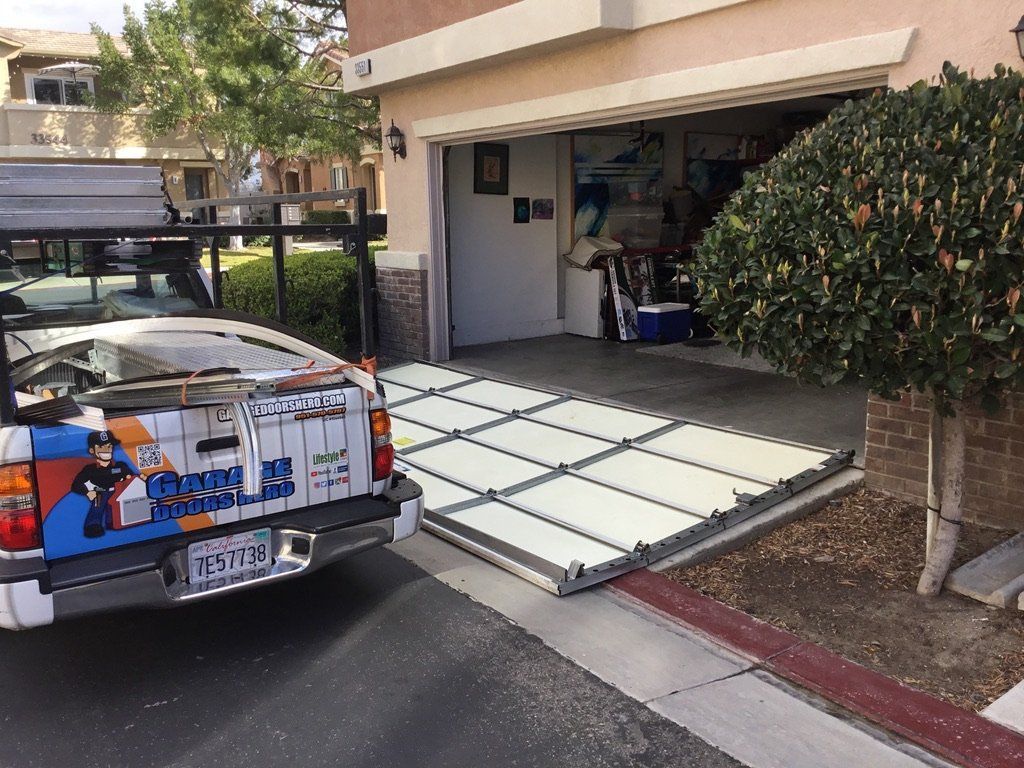 A truck with a license plate that says tf72 is parked in front of a garage.