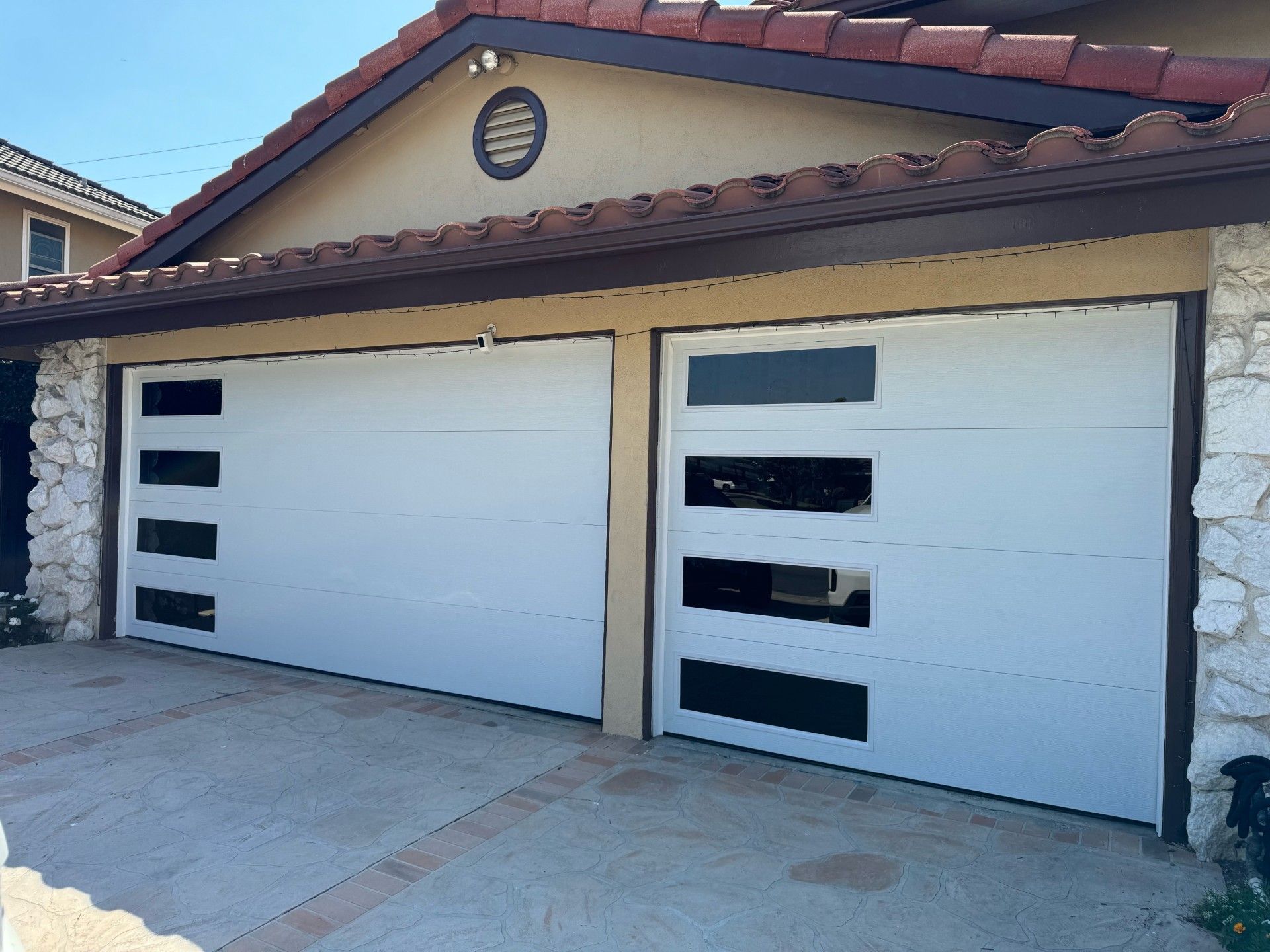 A white garage door with custom glass on it