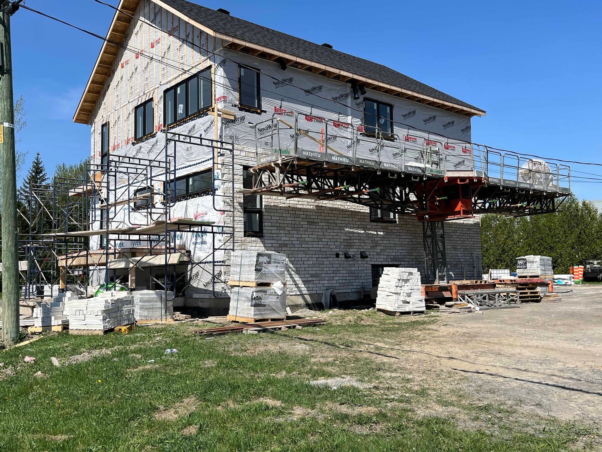 Une grande maison est en construction avec des échafaudages autour.