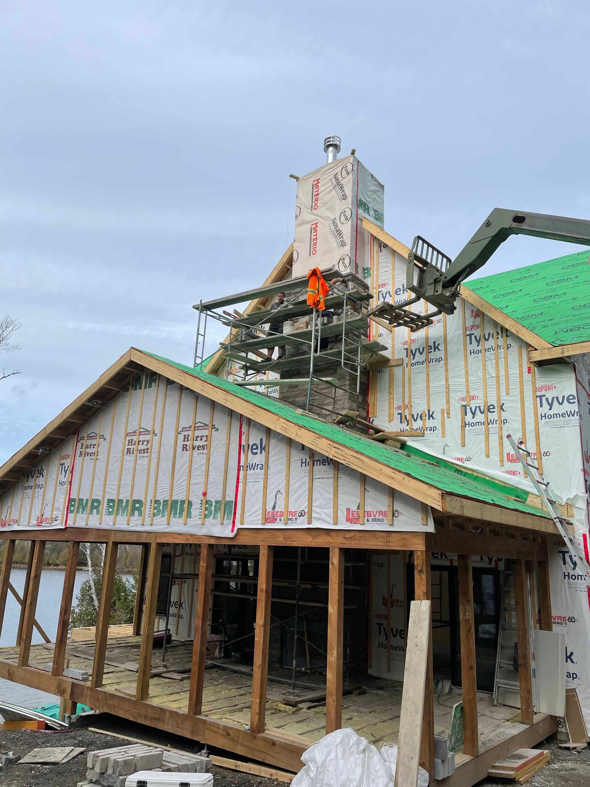 Une maison est en construction avec un toit vert.