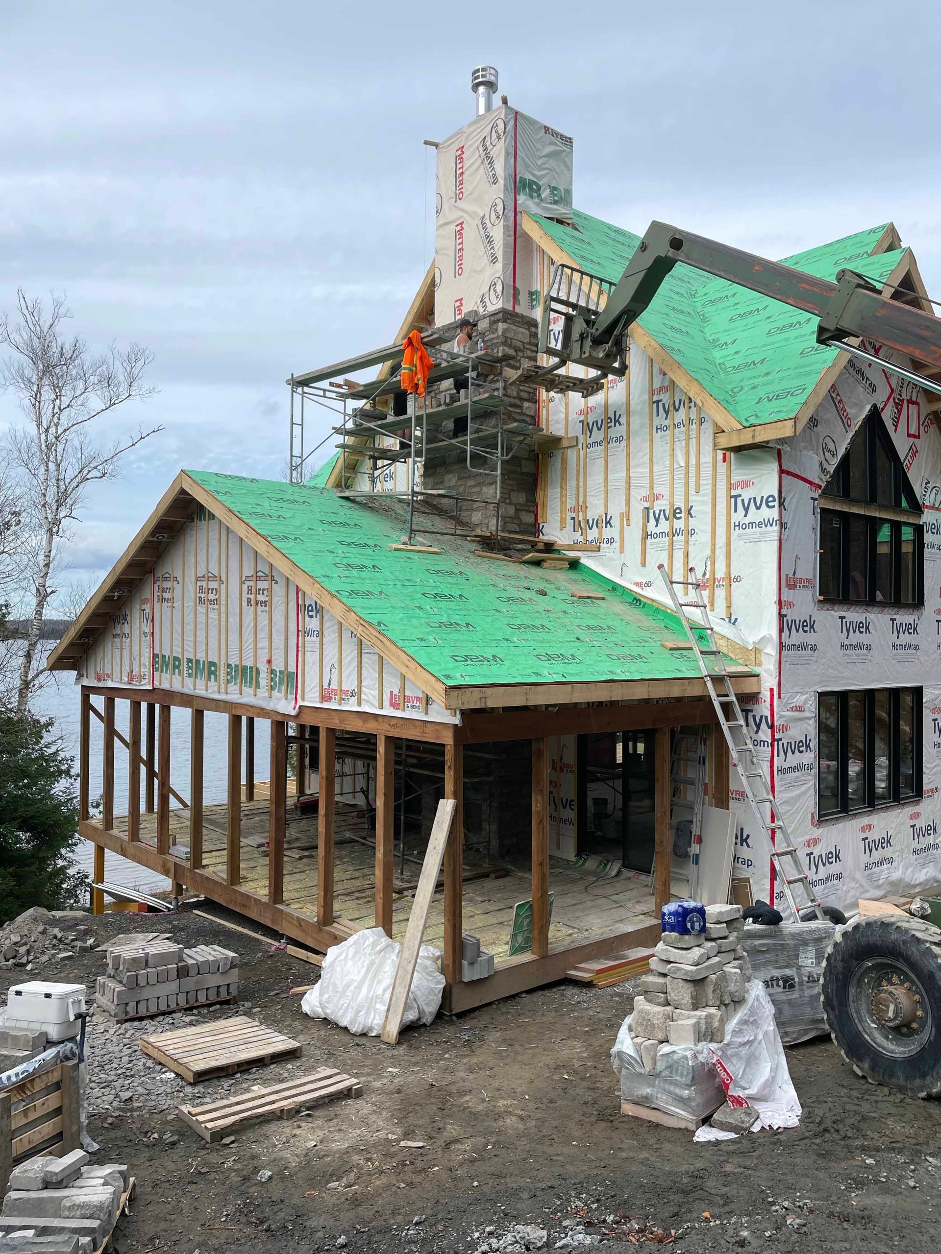 Une grande maison est en construction avec un toit vert.