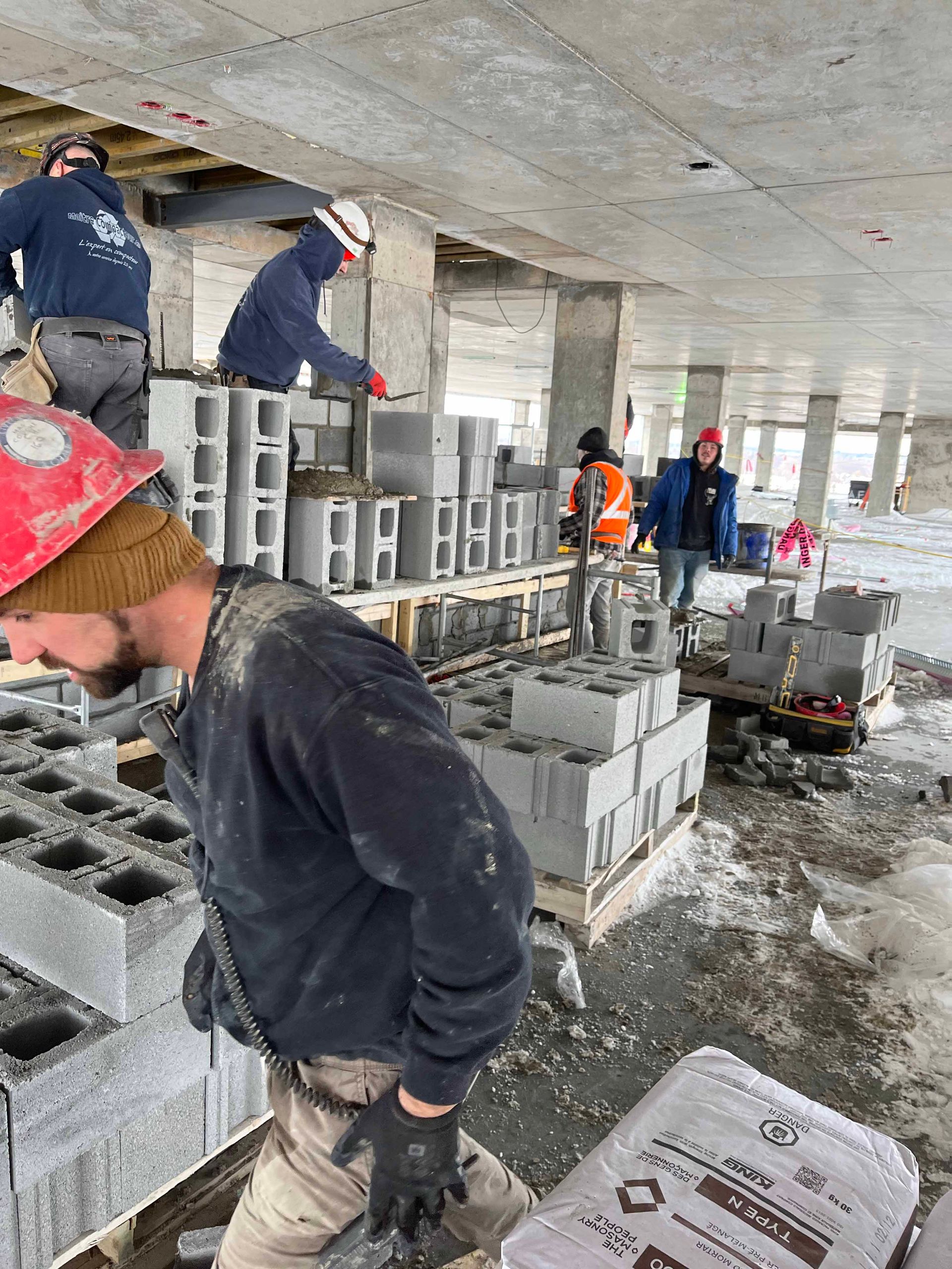 Un groupe d'ouvriers du bâtiment travaille sur un bâtiment en construction.