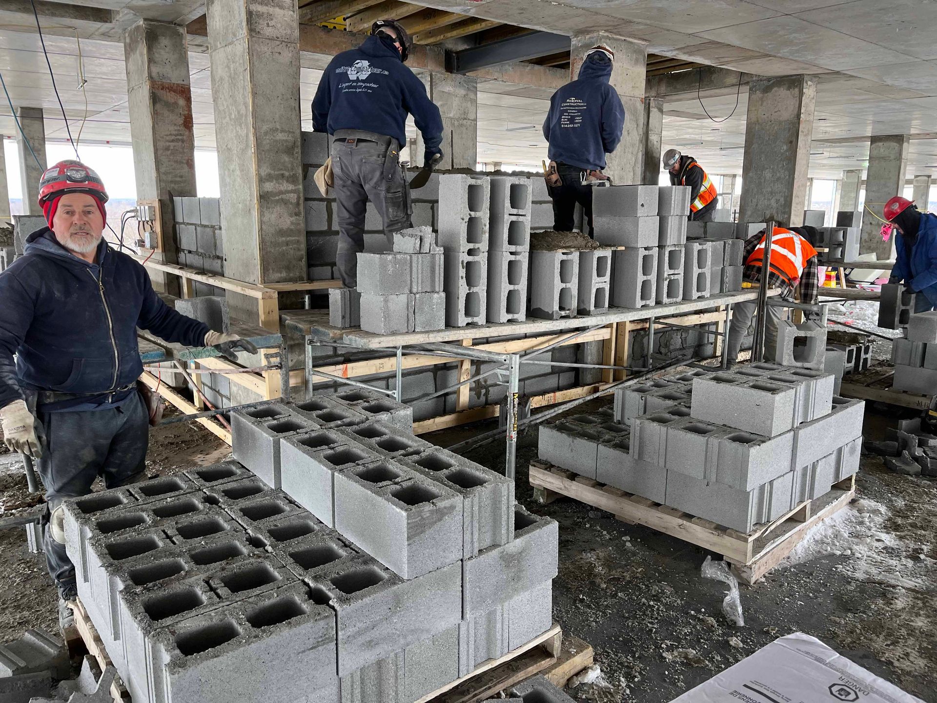 Un groupe d'ouvriers du bâtiment travaille sur un bâtiment en construction.