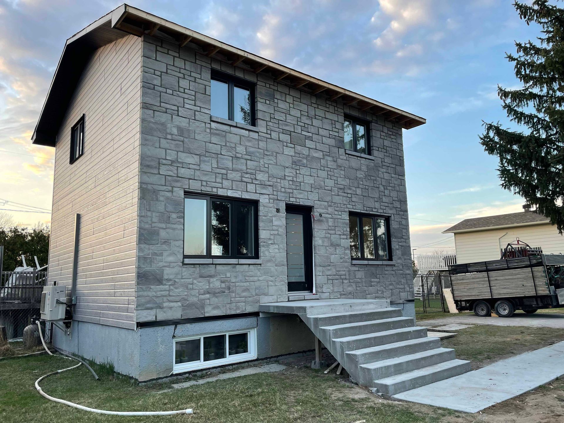 Une grande maison en briques avec des escaliers menant à la porte d'entrée.