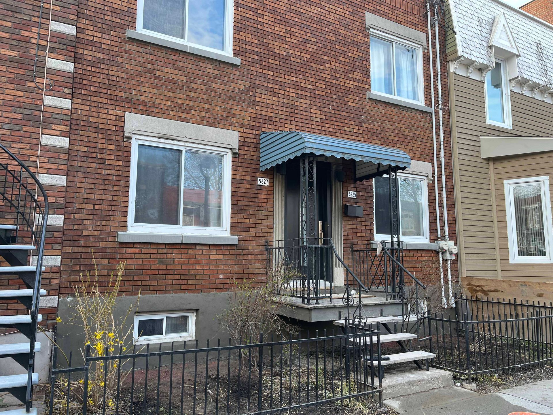 Un bâtiment en briques avec des escaliers menant à la porte d'entrée.
