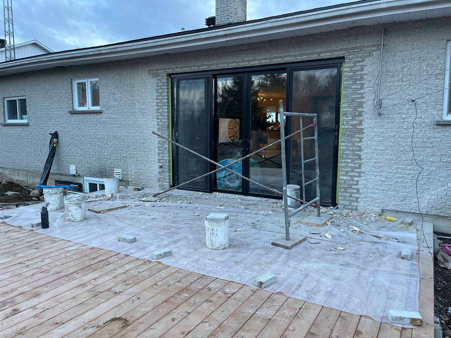 Une maison avec une terrasse en bois devant elle est en cours de rénovation.