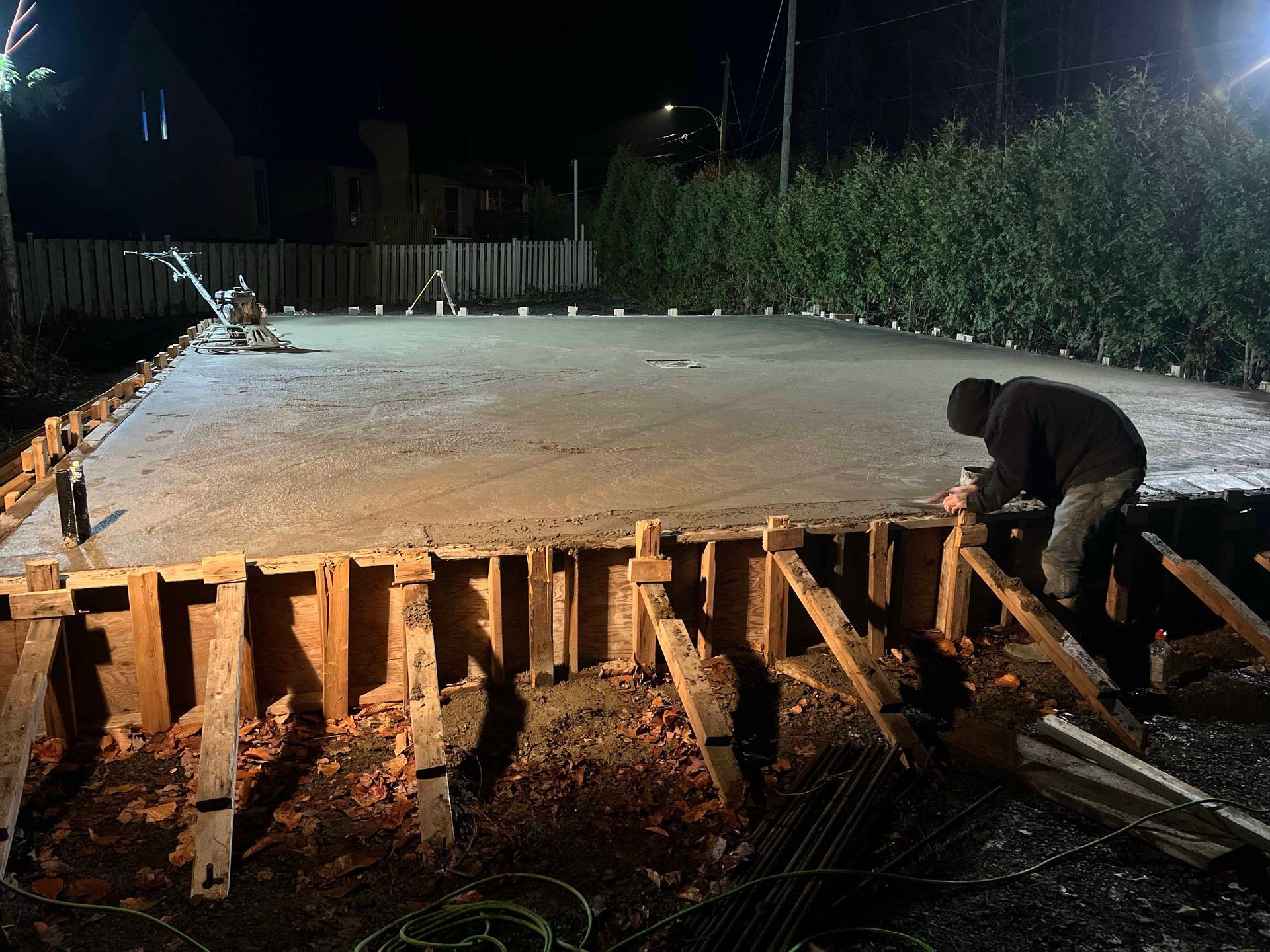 Un homme travaille sur une dalle de béton la nuit