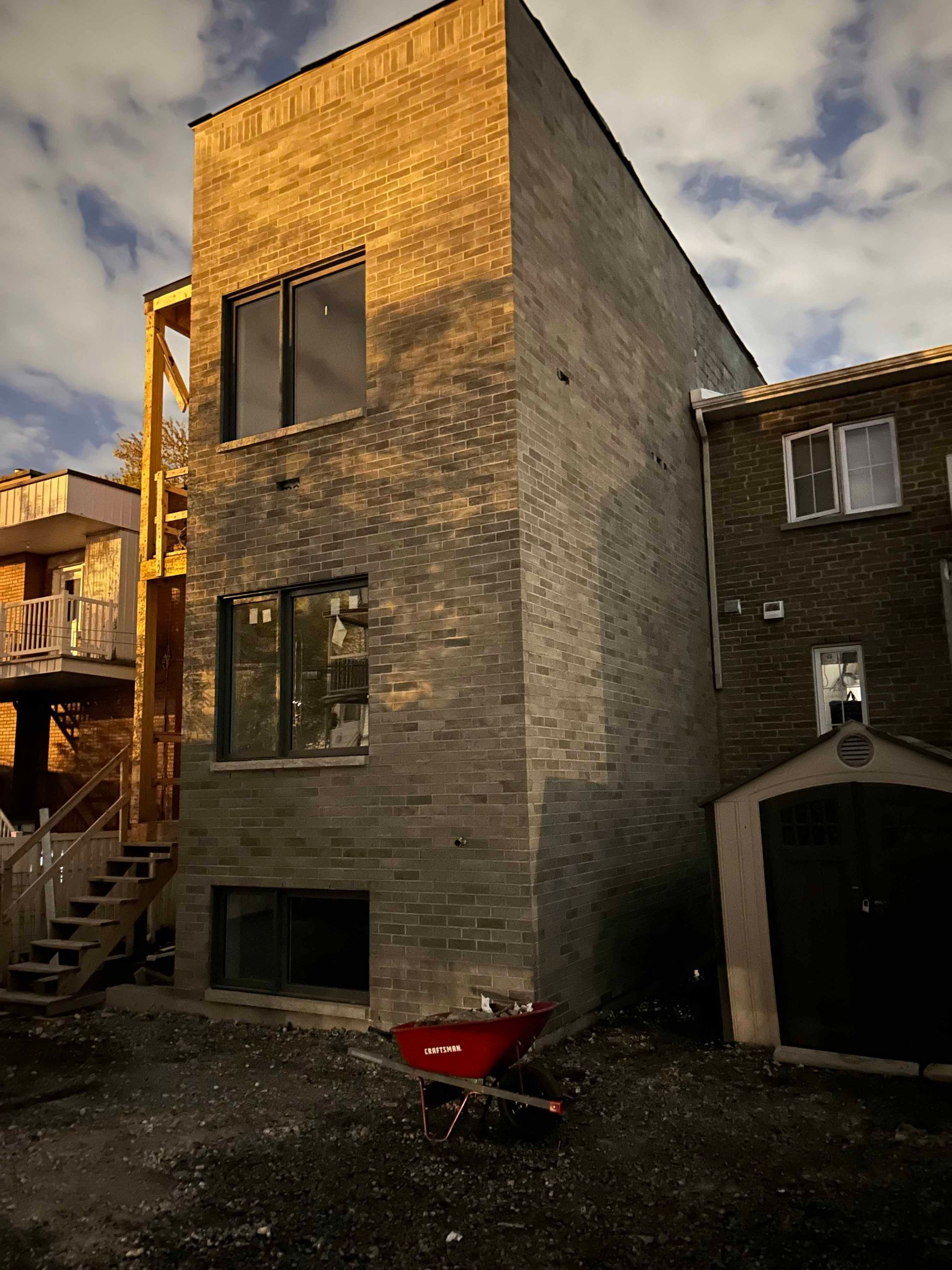 Un grand bâtiment en briques avec une brouette rouge devant