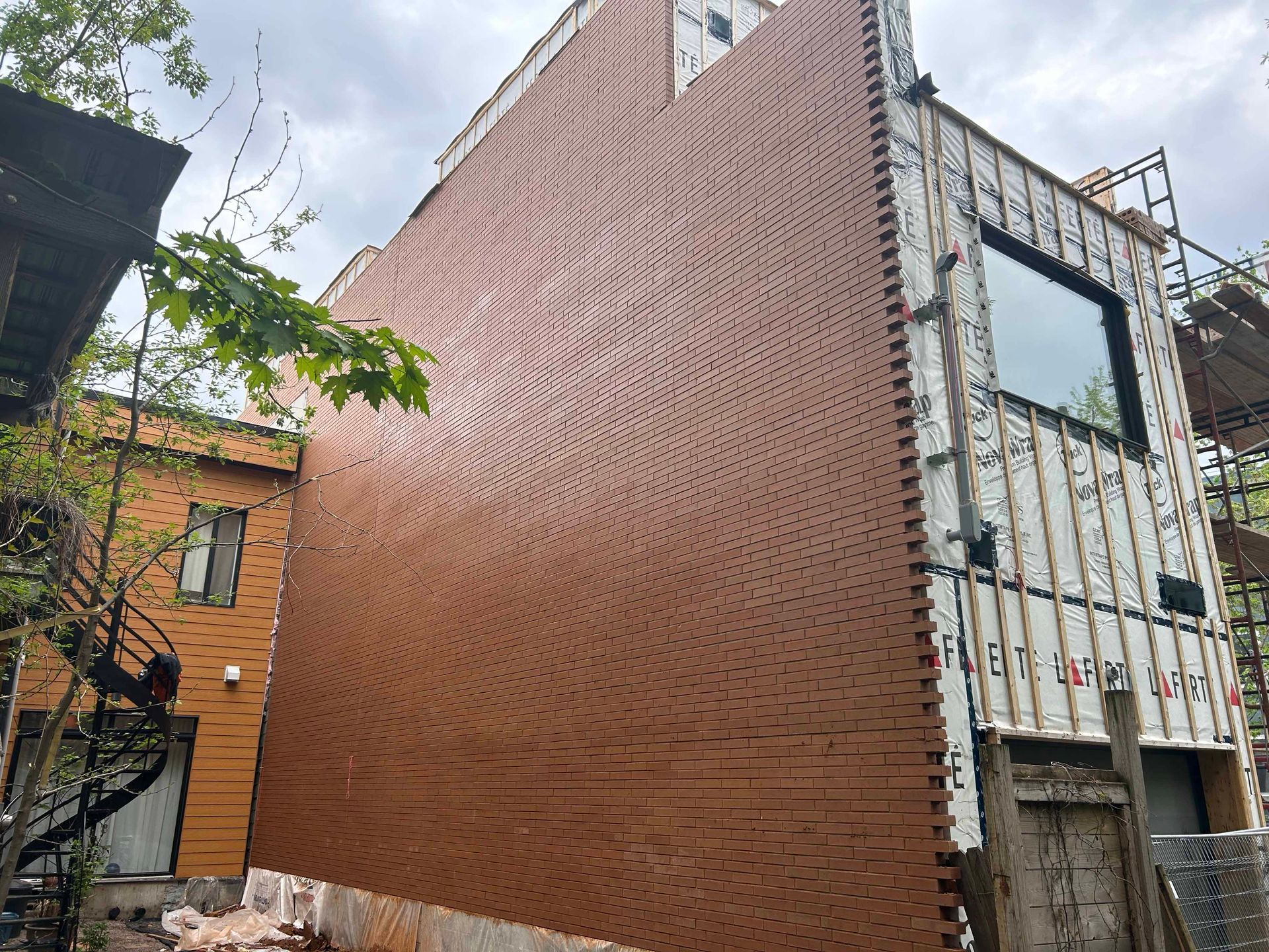 Un bâtiment en construction avec un grand mur de briques et une fenêtre.