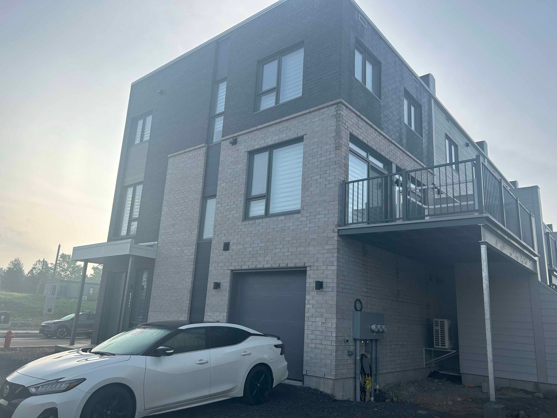 Une voiture blanche est garée devant un grand bâtiment.