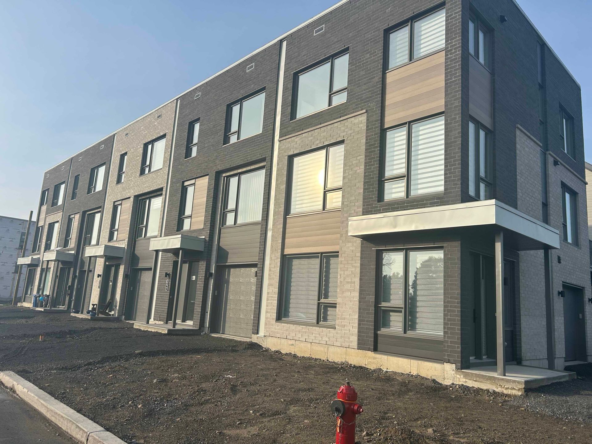 Un grand bâtiment avec une borne d'incendie devant lui.