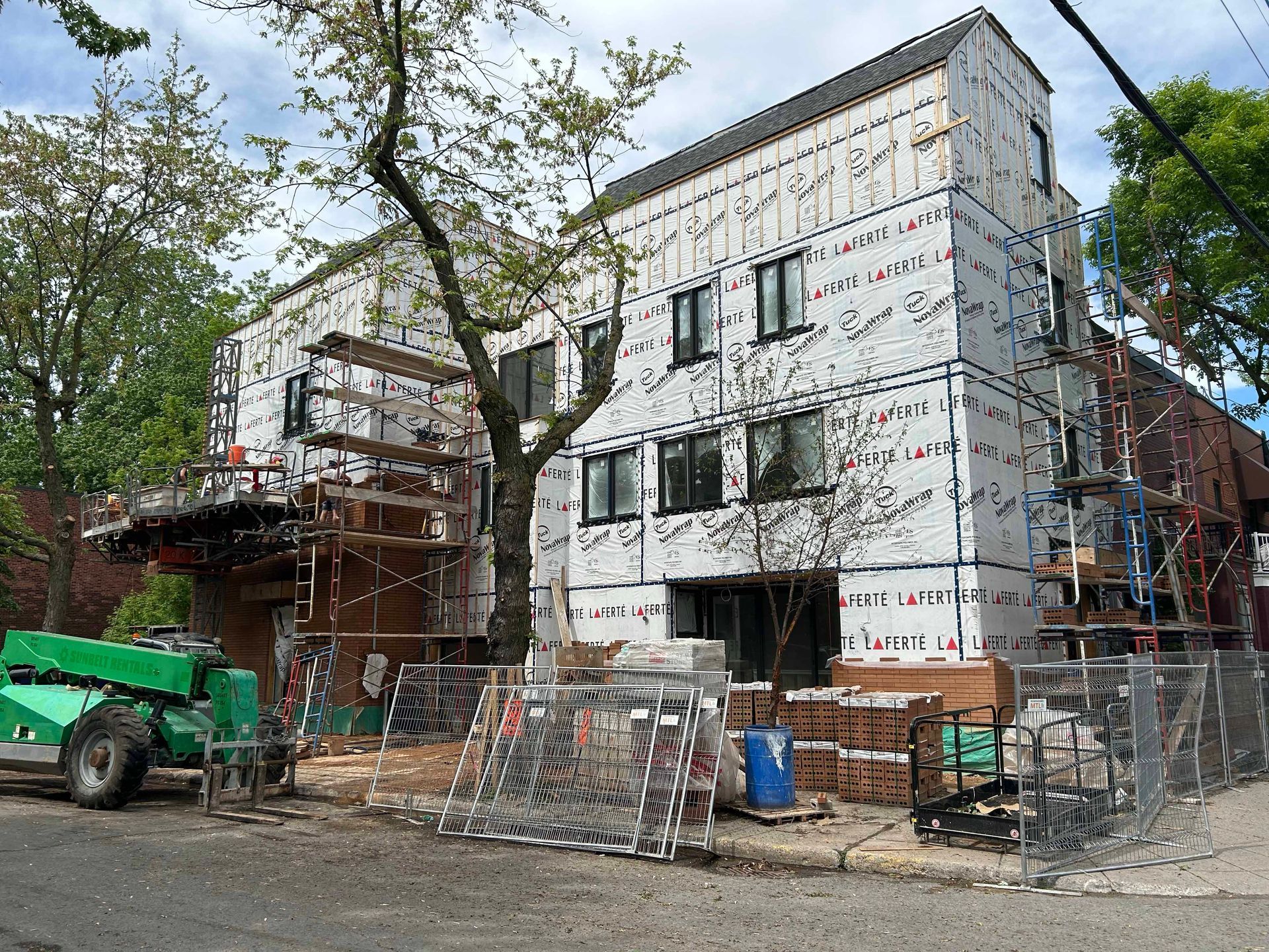 Un bâtiment en construction avec un tracteur vert garé devant