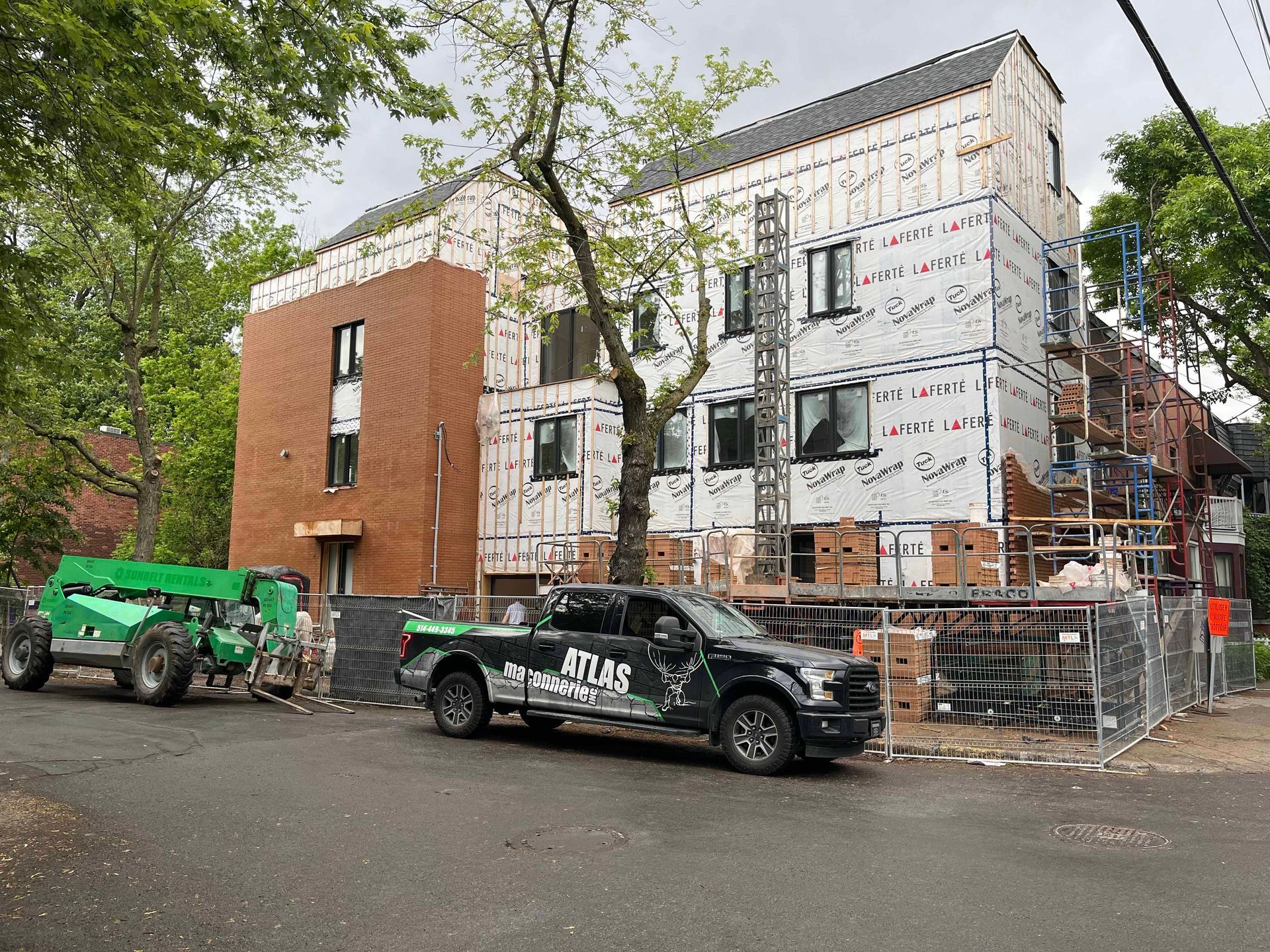 Un camion est garé devant un bâtiment en construction.