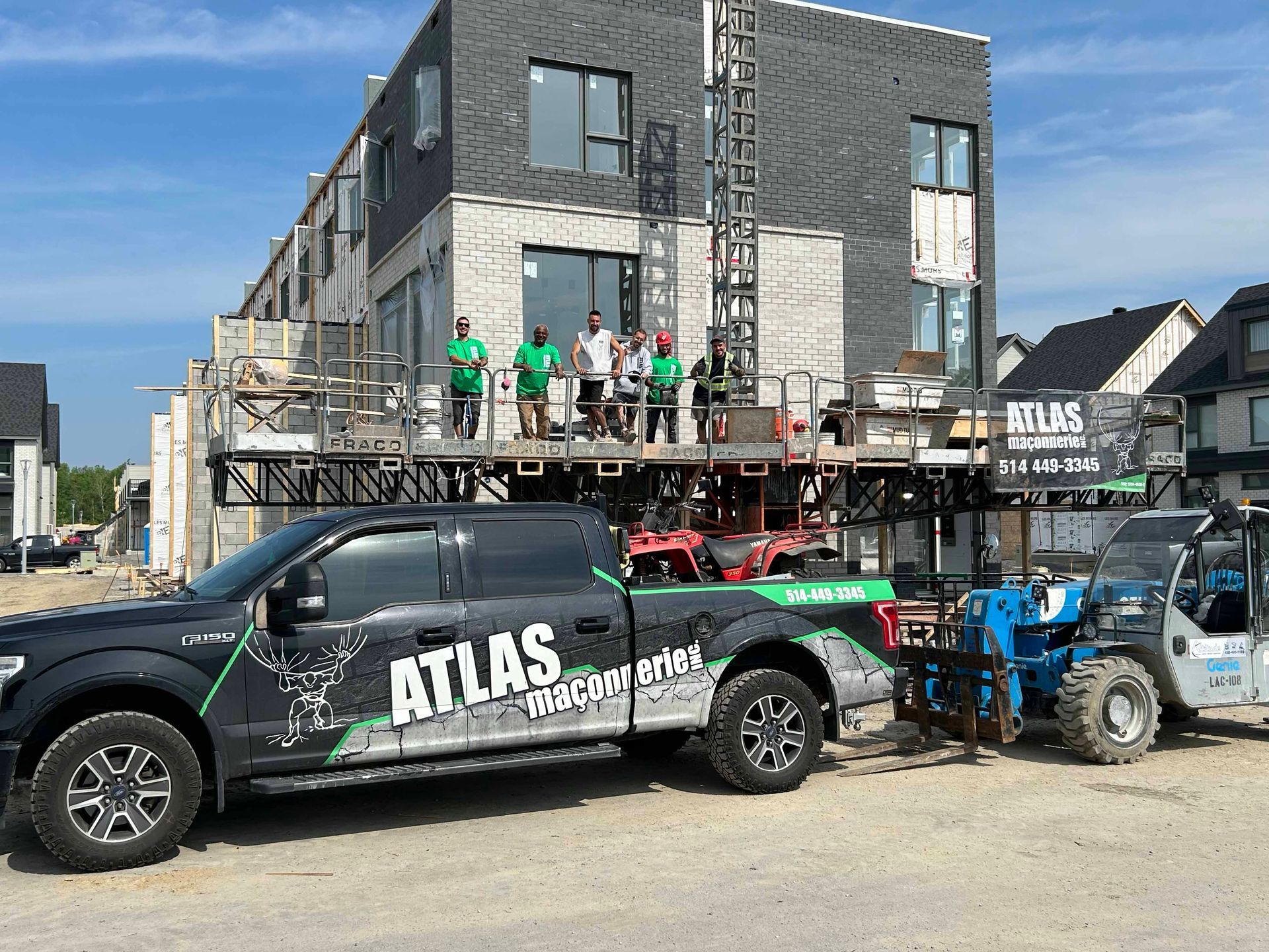 Un camion atlas noir est garé devant un bâtiment en construction.