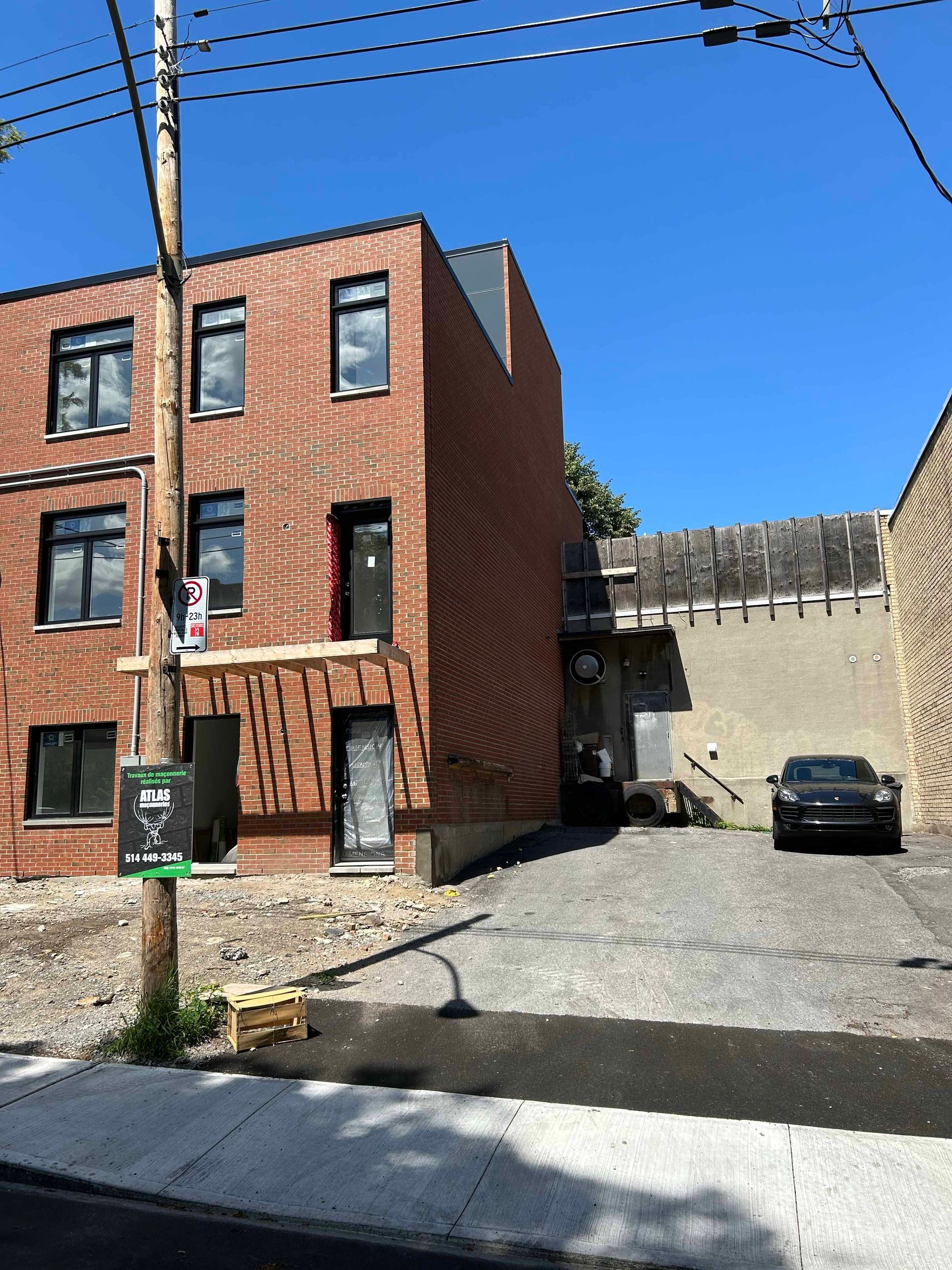 Un bâtiment en briques avec une voiture garée devant