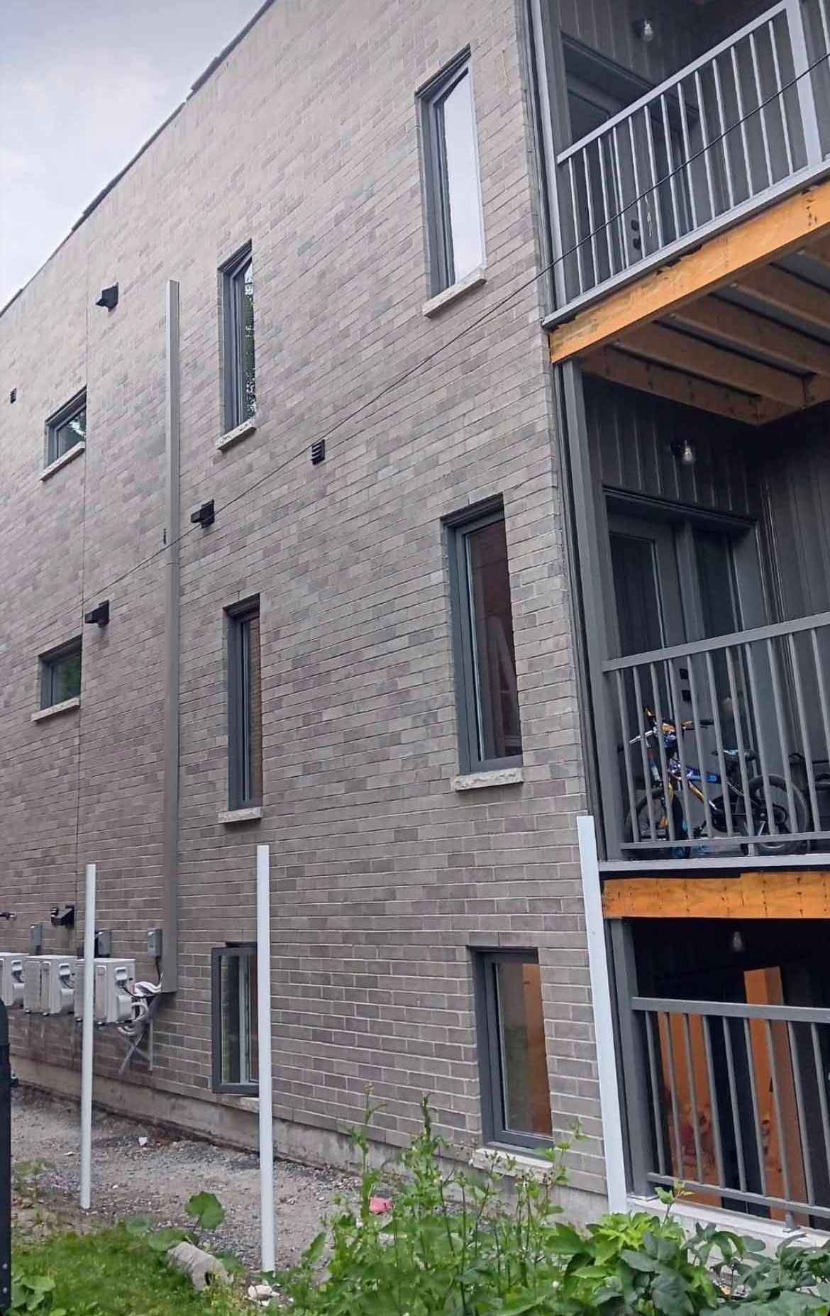 Un grand bâtiment en briques avec un balcon et une clôture devant.