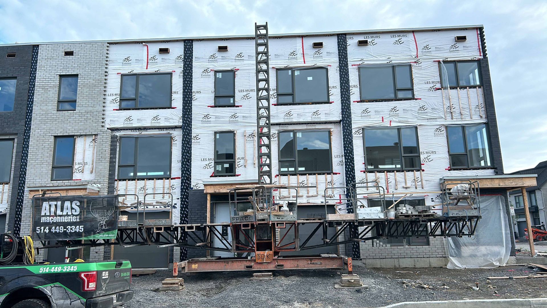 Un bâtiment en construction avec un camion garé devant.