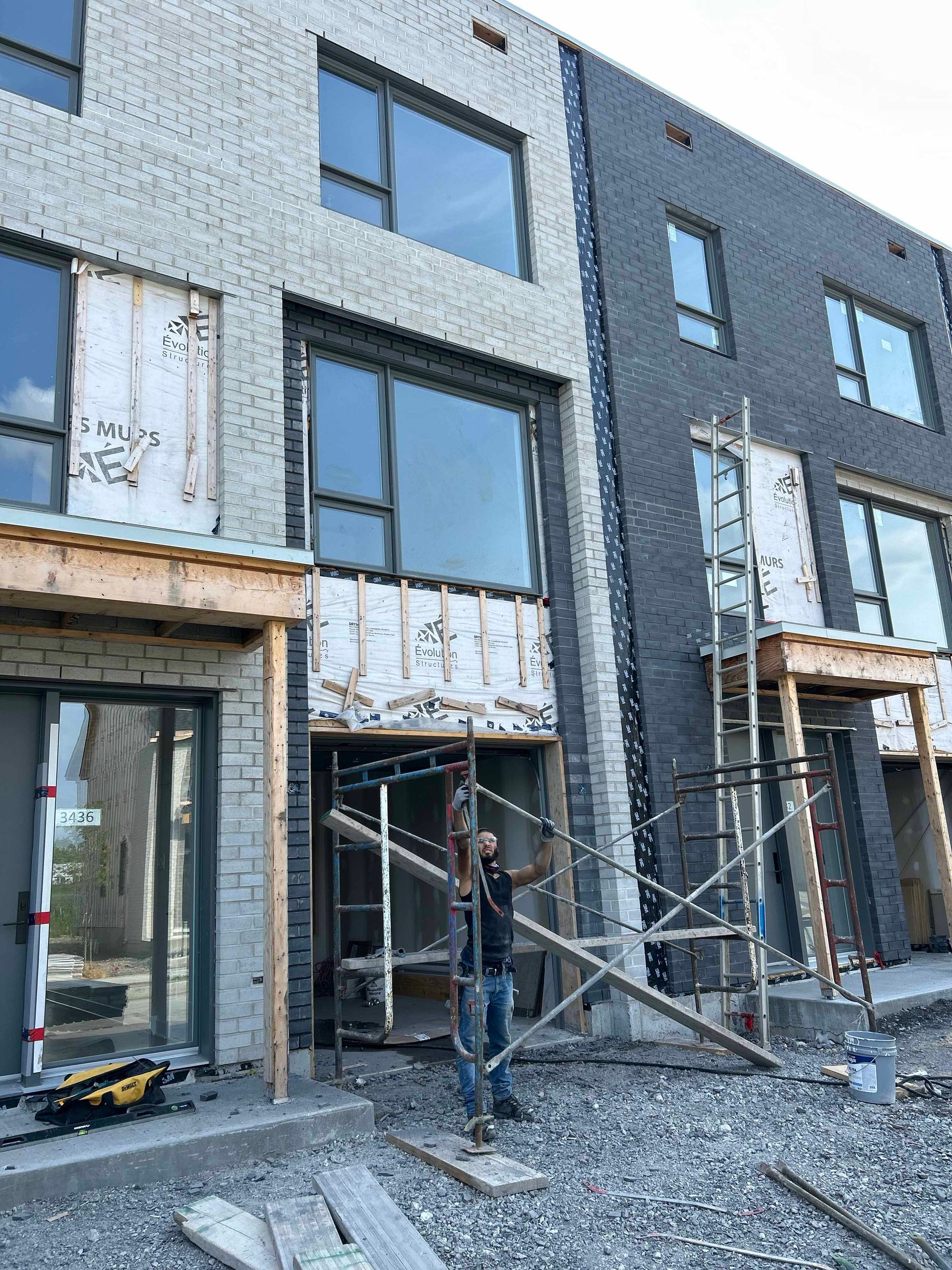 Un homme se tient devant un bâtiment en construction.